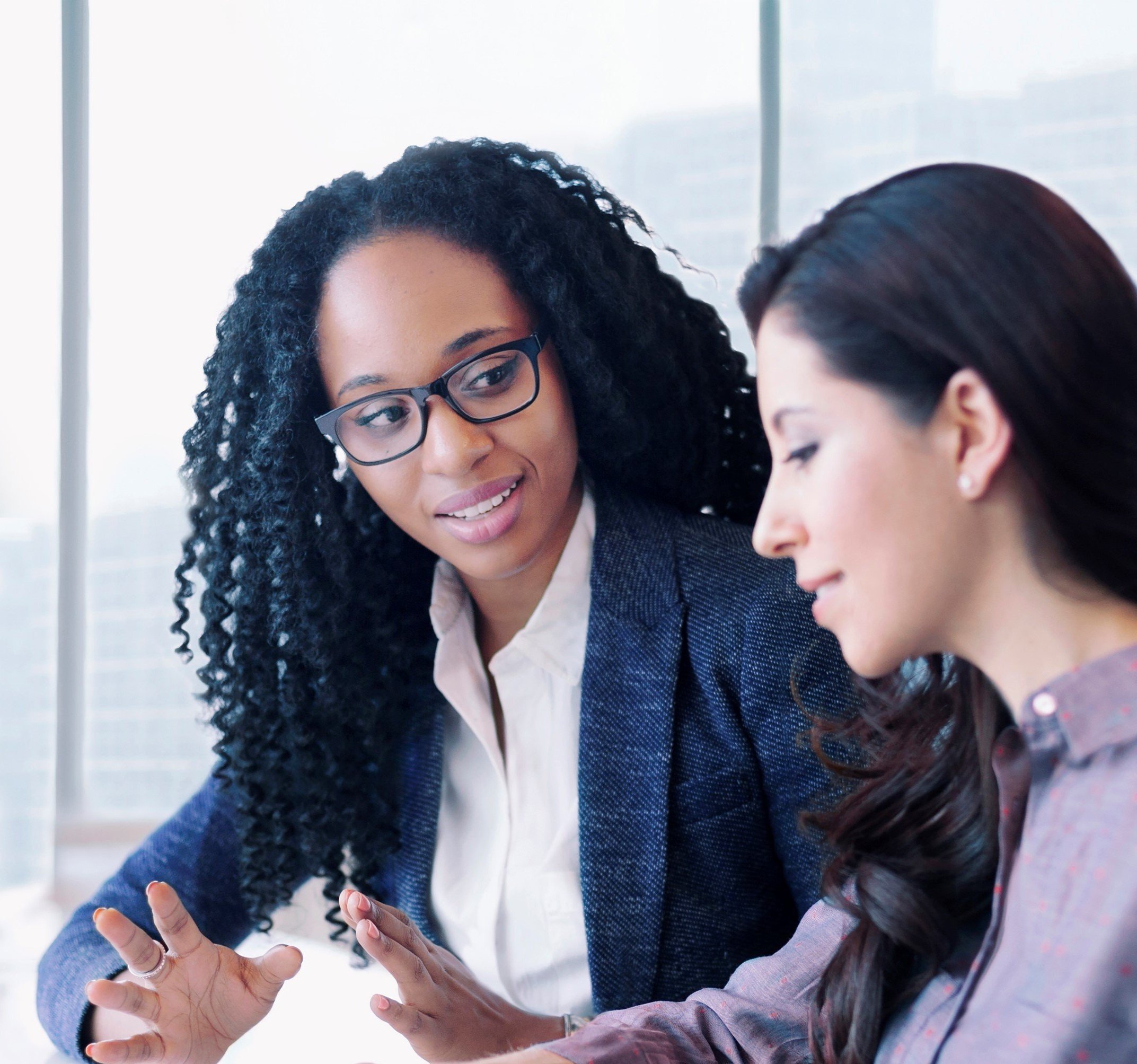 A black woman giving a hispanic woman a Psychological Evaluation during a Counseling session.