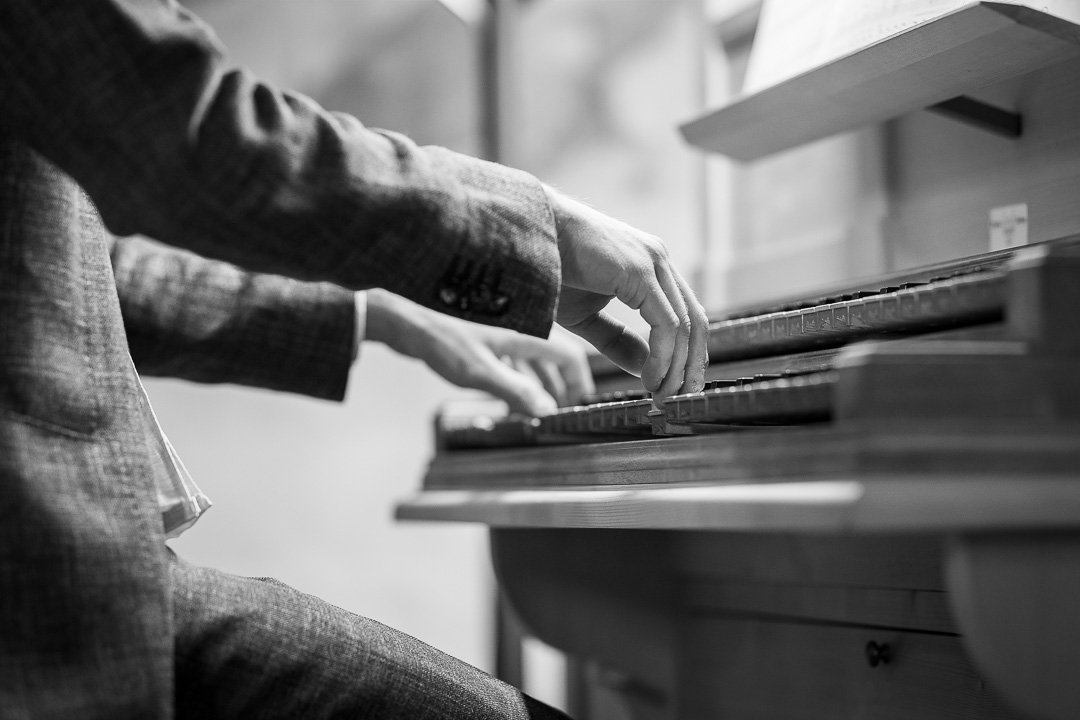 Person, die Orgel spielt, schwarz-weiß