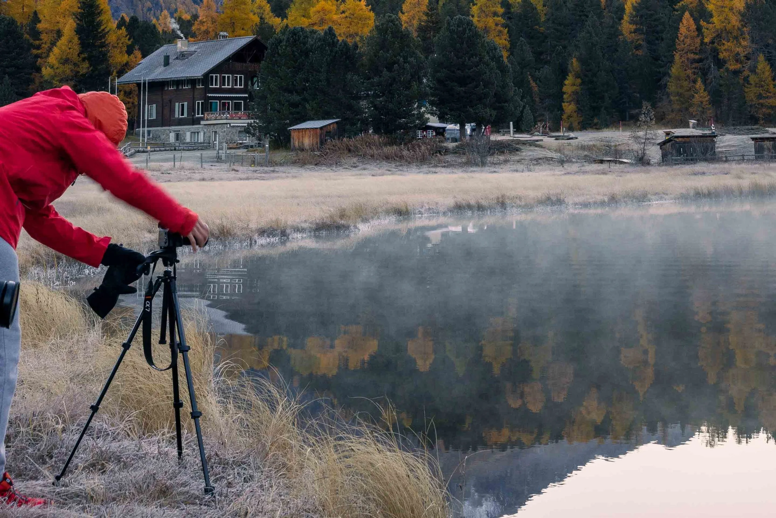Fotograf beim Fotografieren der Morgenstimmung am Stazersee im herbstlichen Engadin.