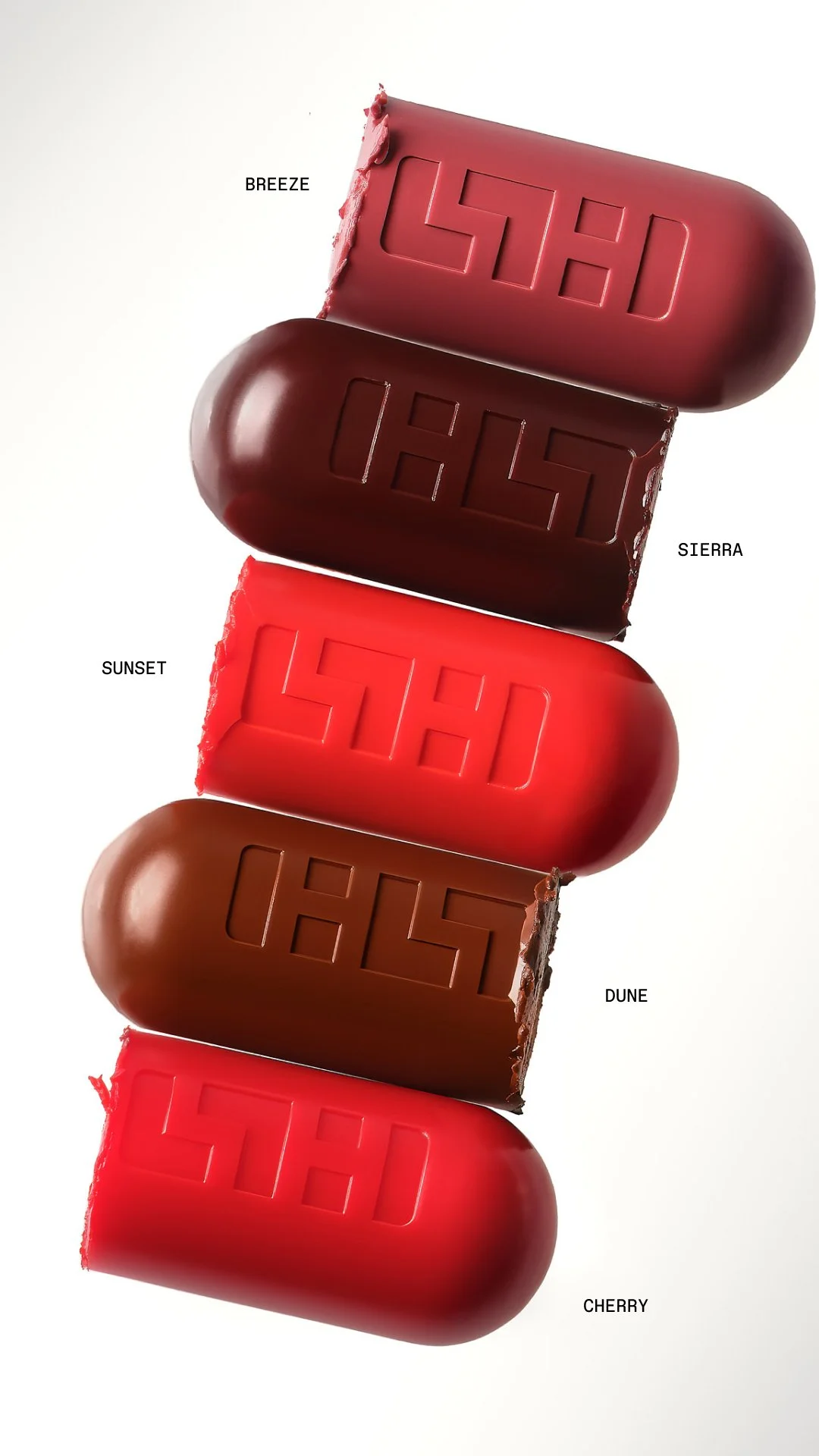 Une image de cinq bouchées de chocolat aux couleurs de différents saveurs : Breeze (violet foncé), Sierra (brun foncé), Sunset (rouge vif), Dune (marron clair), Cherry (rouge foncé).