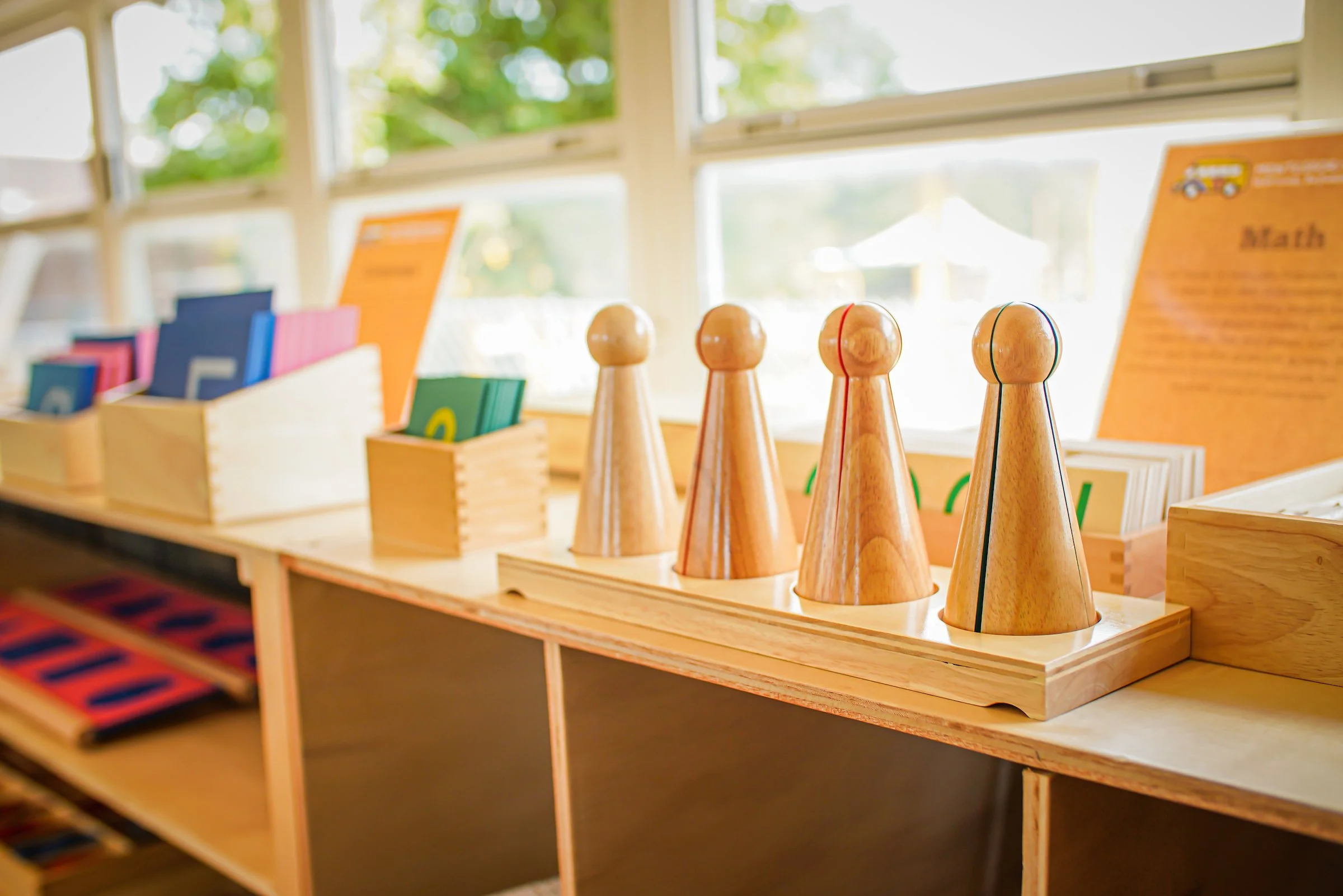 the math shelf is shown, with the fractions manipulatives at the foreground and sandpaper numbers further back