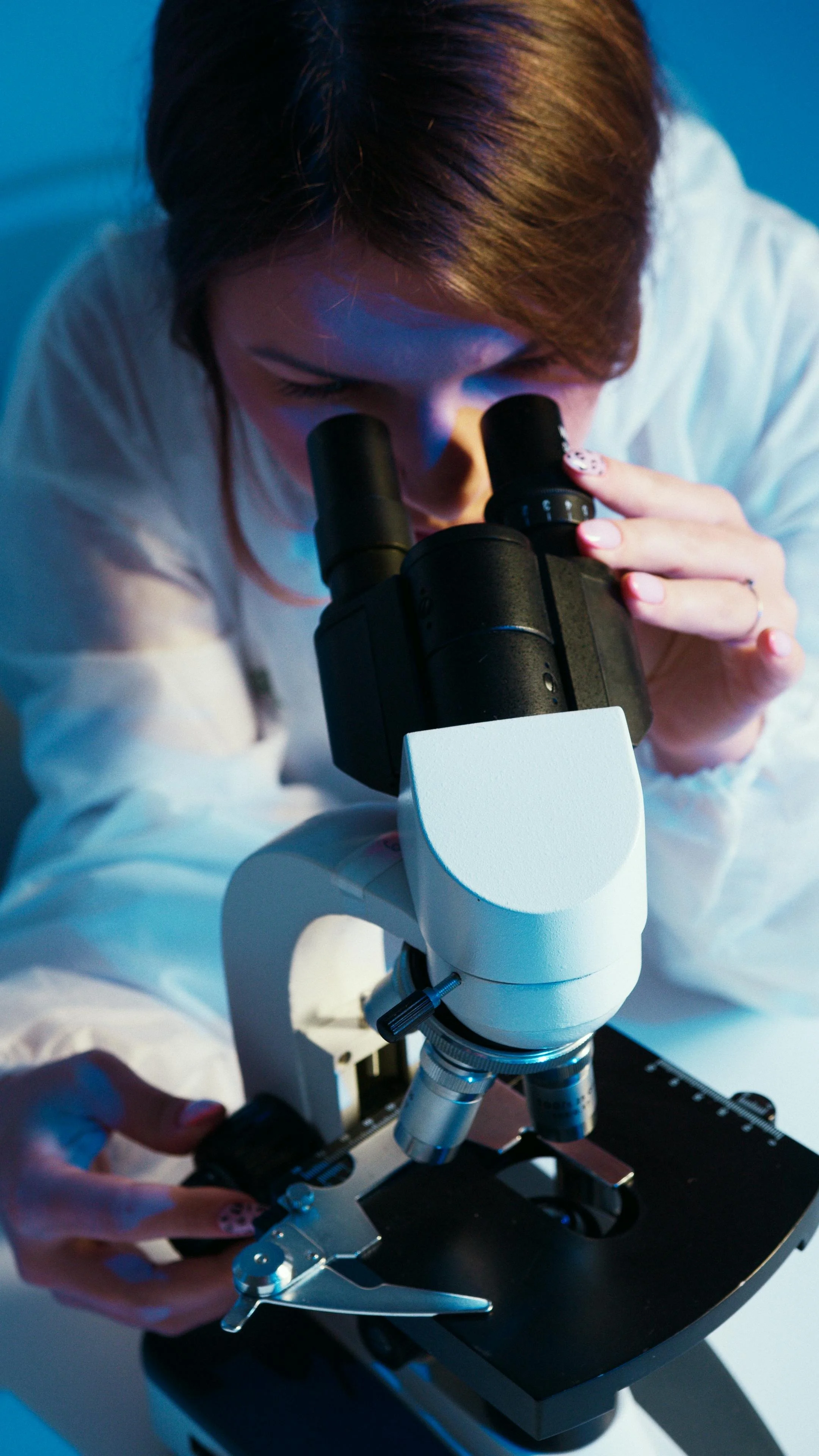 oncologist peering into a microscope