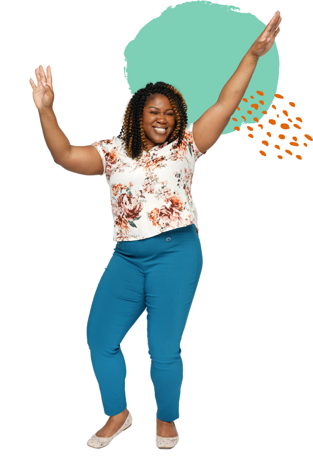 A joyful woman with curly hair wearing a floral blouse, teal pants, and beige flats, smiling with arms raised in celebration.