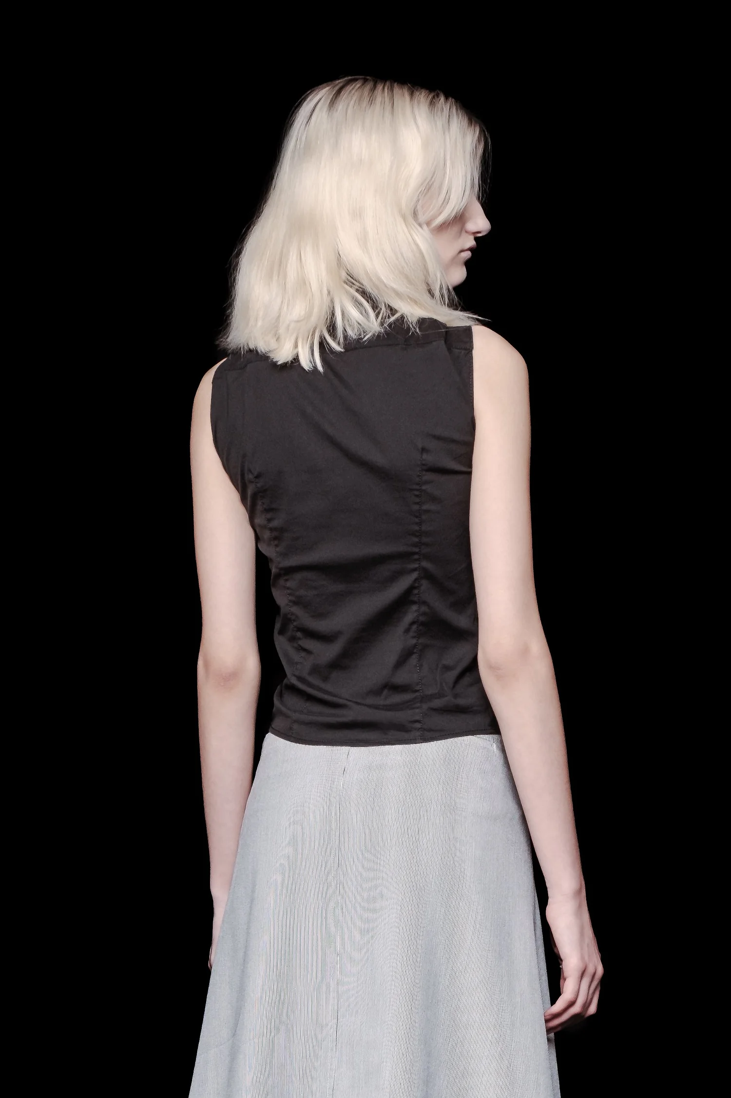 Back view of Prada sleeveless asymmetrical button up top.