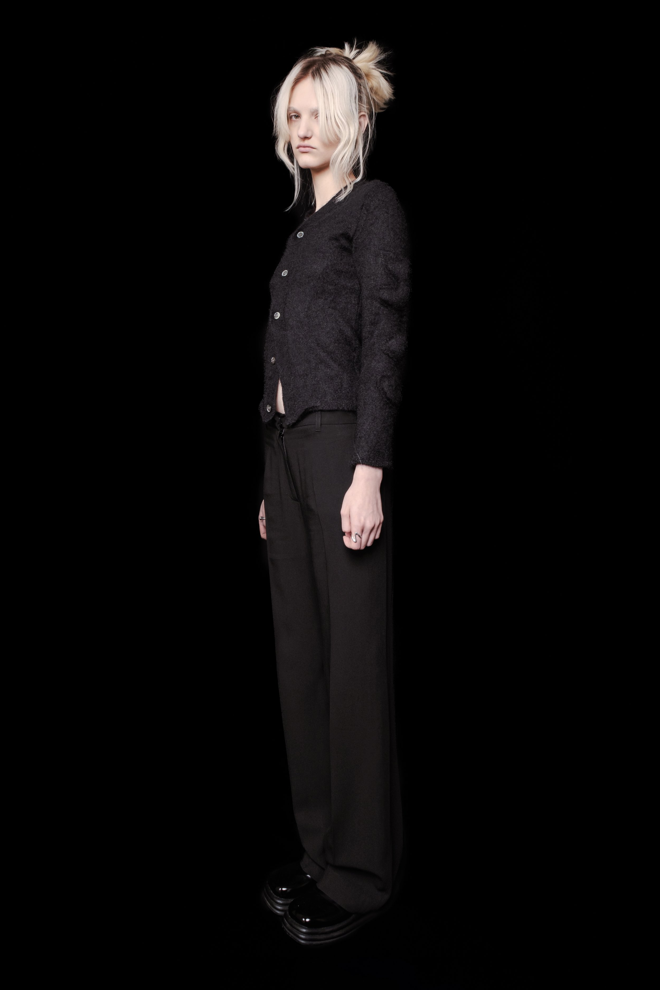 Side view of Ann Demeulemeester black straight leg trousers.