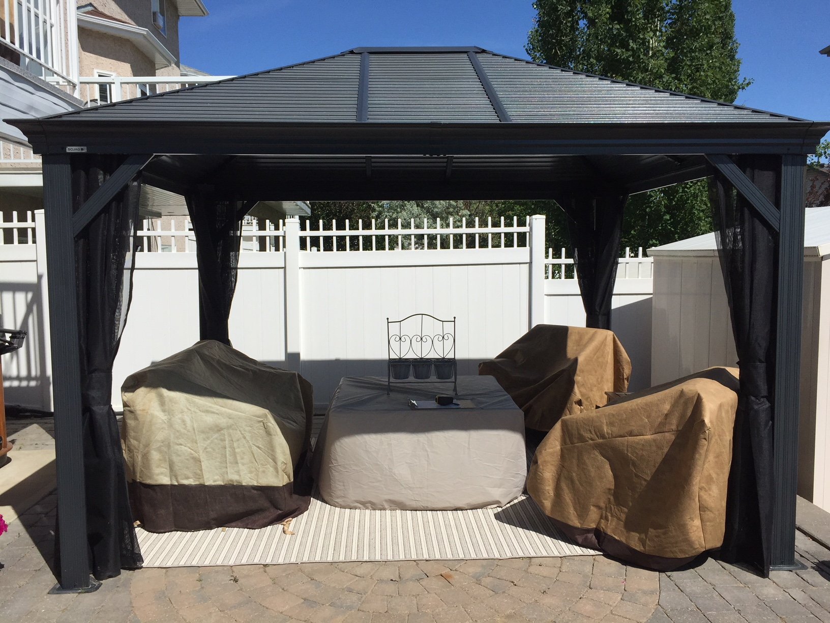 Premanufactured metal gazebo on paving area.