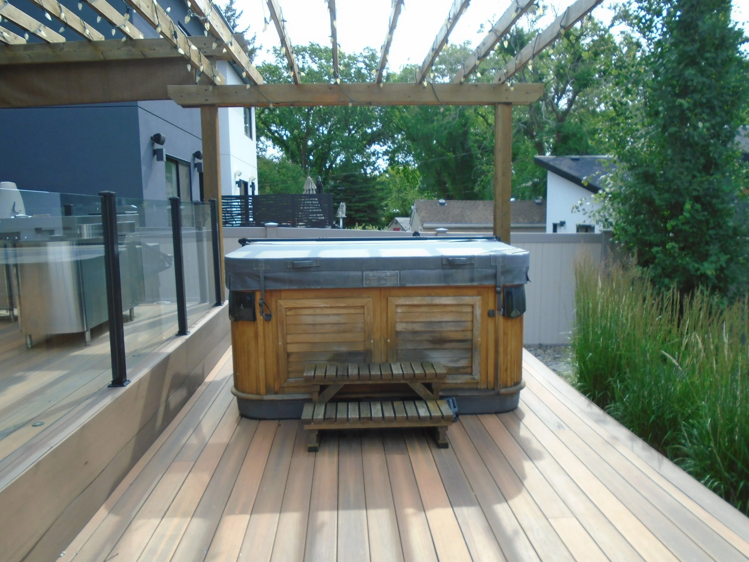 Hot tub with lid located on a wood deck.