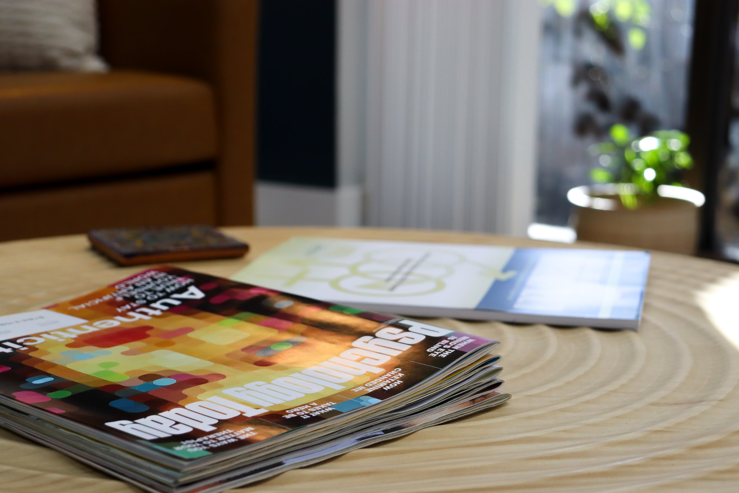 Therapy office lobby with stack of magazines on coffee table including Psychology today