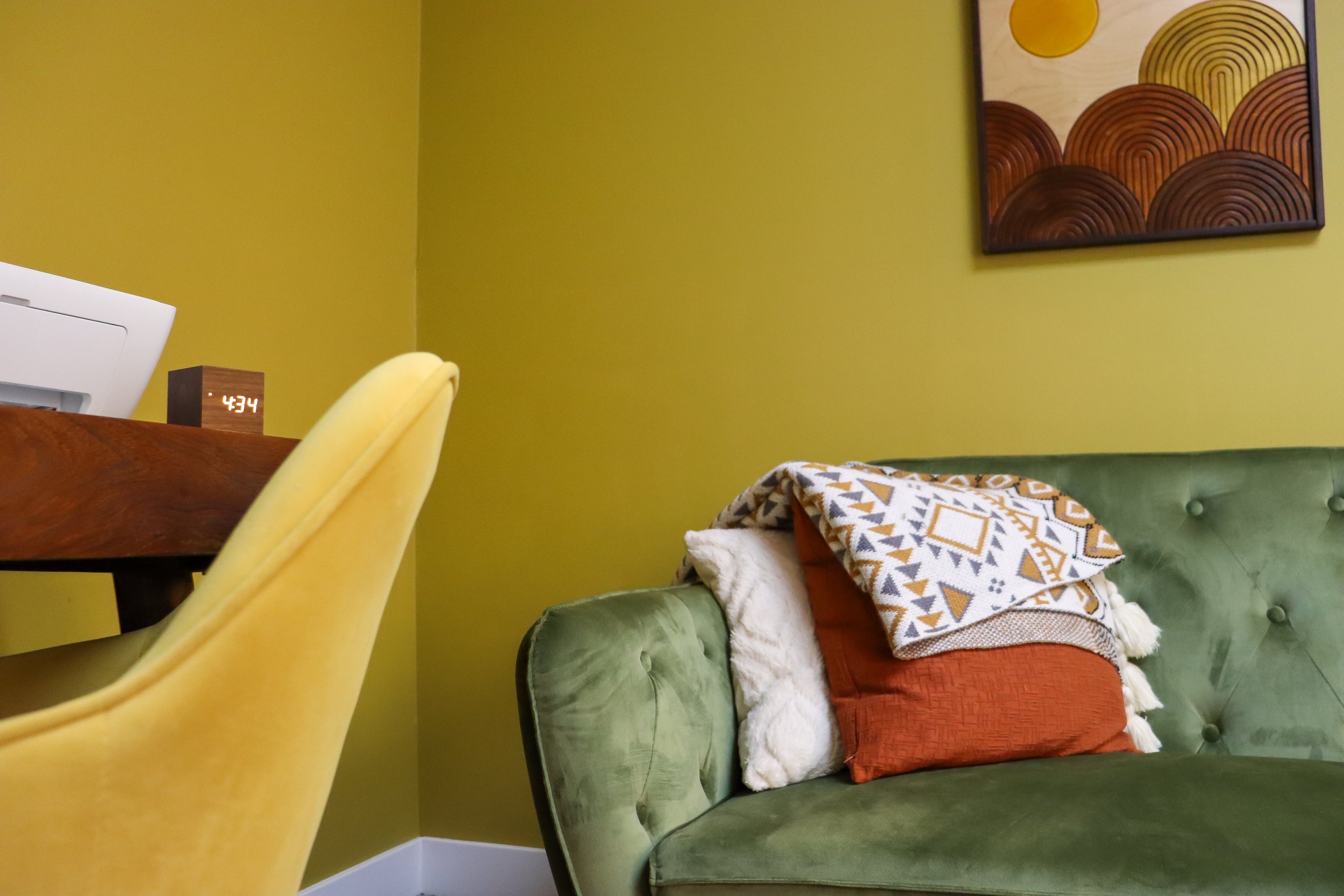 Warm yellow office with green couch and modern desk for a therapy offie rental