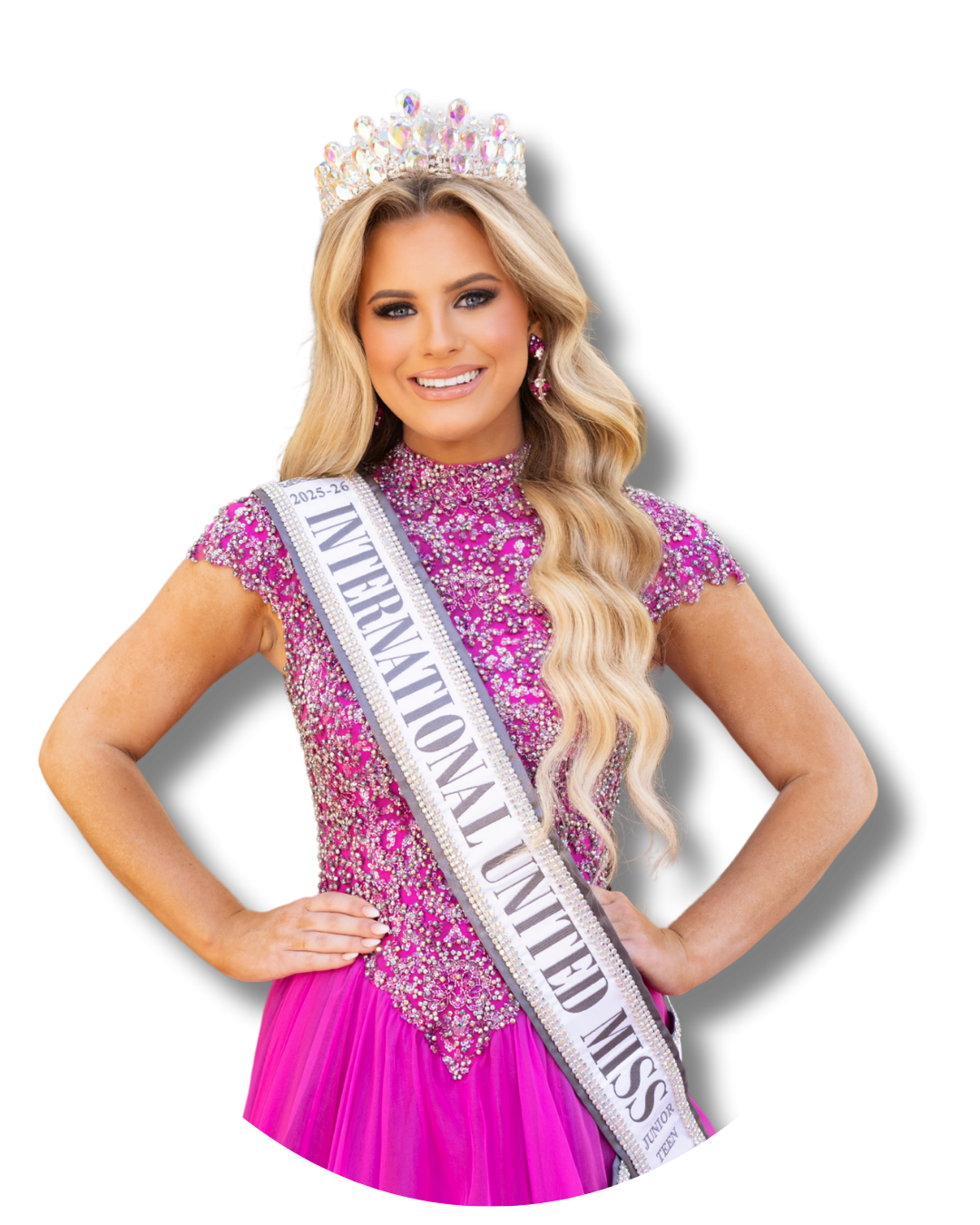 Beauty queen wearing a crown, pink gown, and sash that reads 'International United Miss 2025-26' smiling with hands on hips.