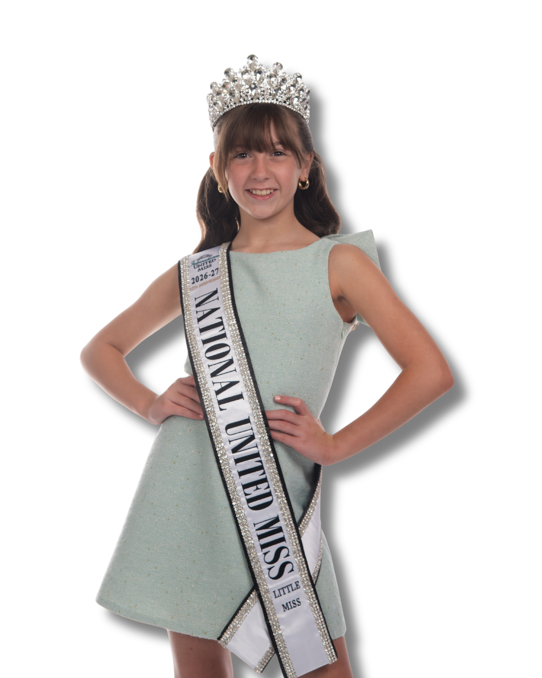 Young girl smiling wearing a blue dress, a crown, and a sash that reads 'National United Miss 2025-26'.