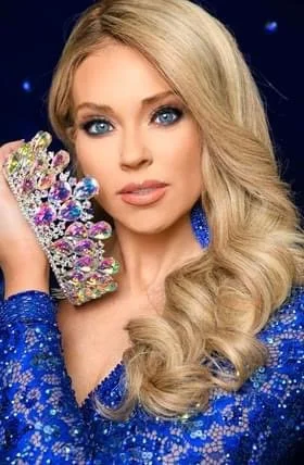 Woman with long blonde hair, blue eyes, and blue dress holding a decorated shoe