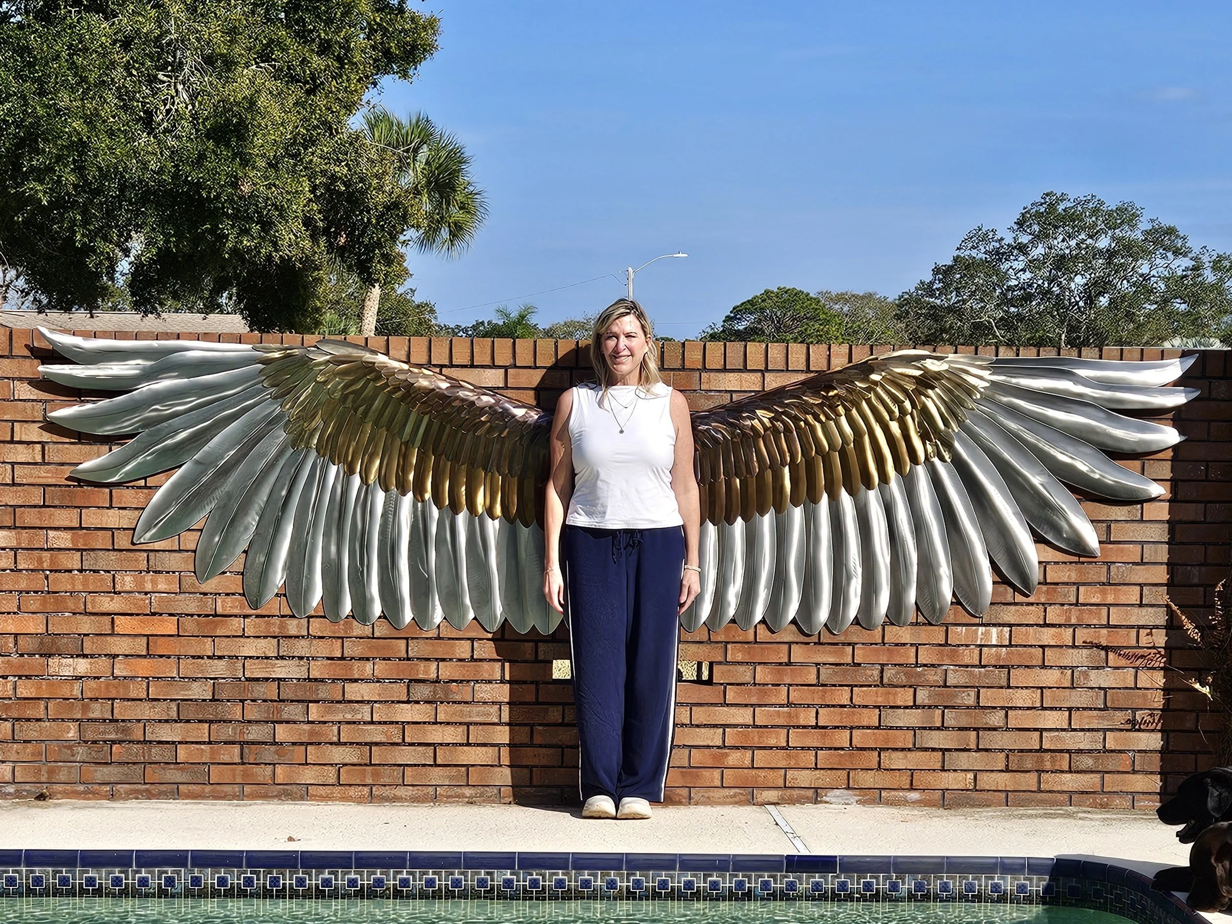 Woman standing with the wings for scale