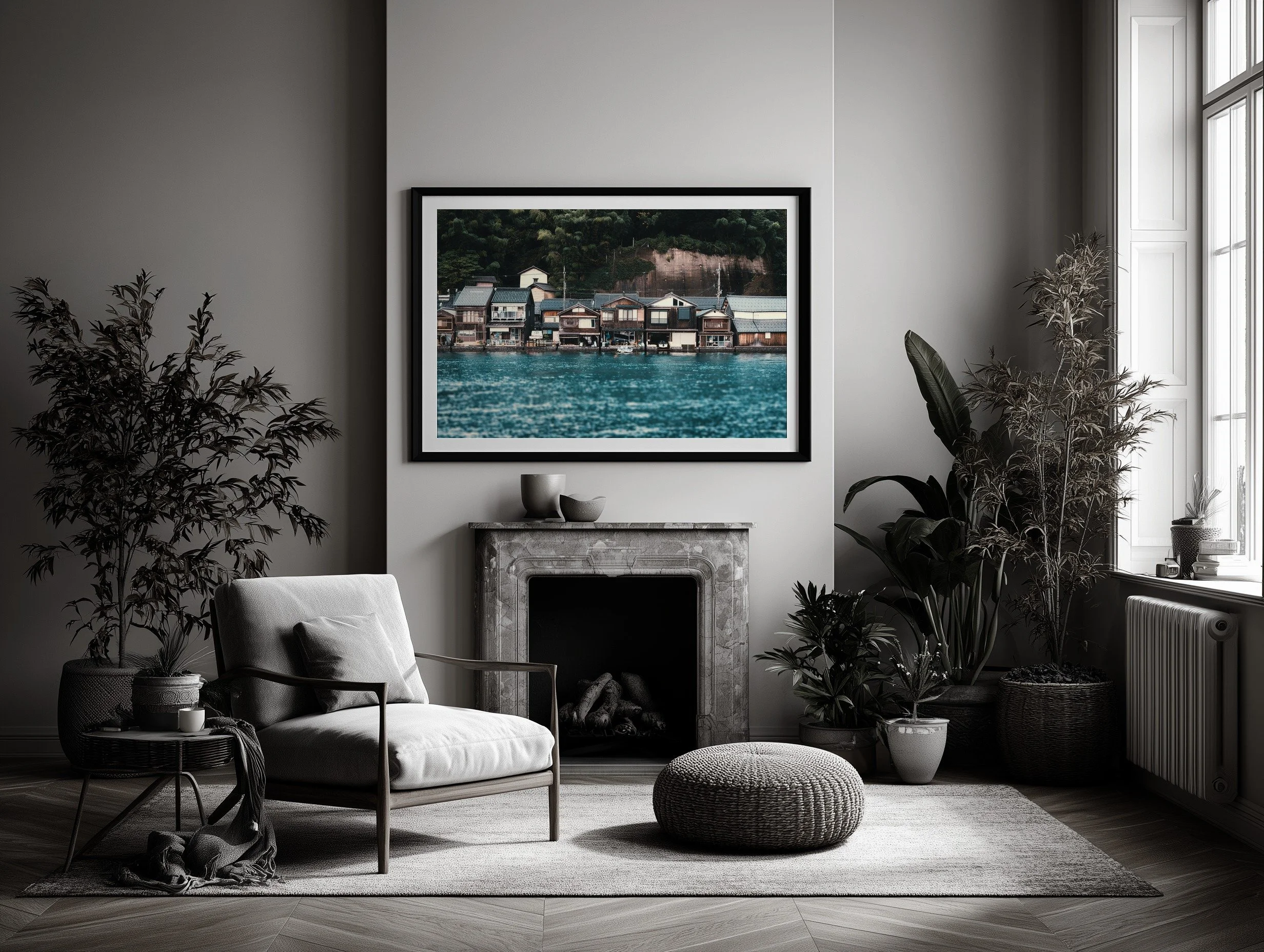 Room mockup of the Ine Bay boathouses photograph in a black frame above a fireplace in a neutral living room.