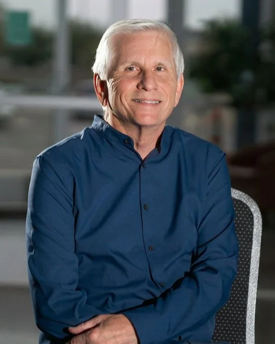 Craig Merrill, Bookkeeper, smiling in a studio portrait wearing a blue button-up shirt.