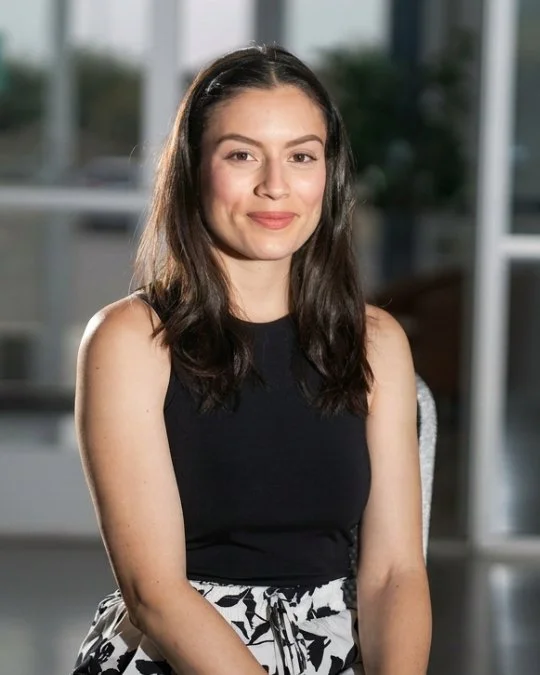 Josie Vargas, Associate Kids Director, smiling in a studio portrait wearing a black sleeveless top.