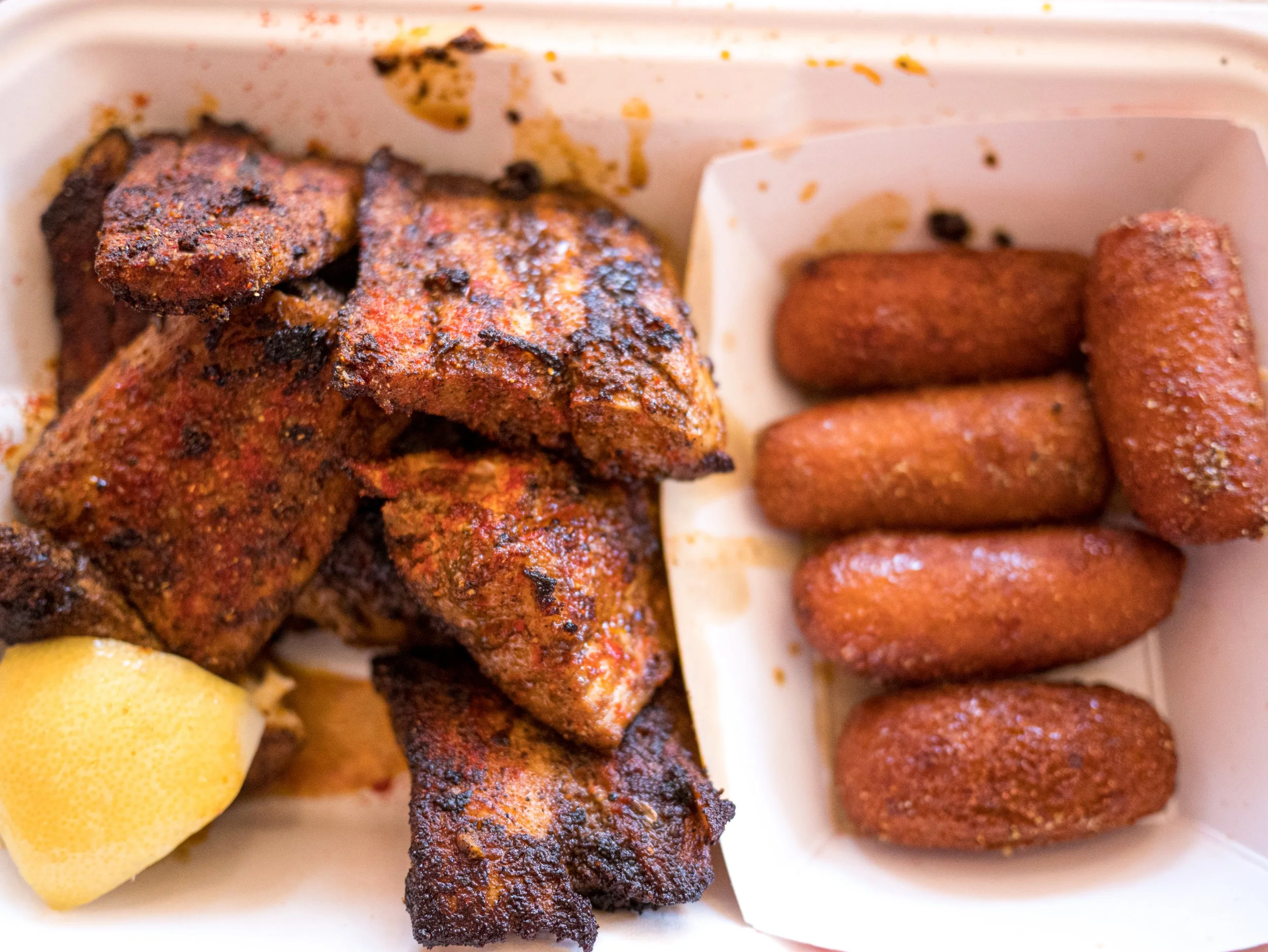 A mahi mahi seafood plate with the blackened fish on the left and hush honeys on the right.