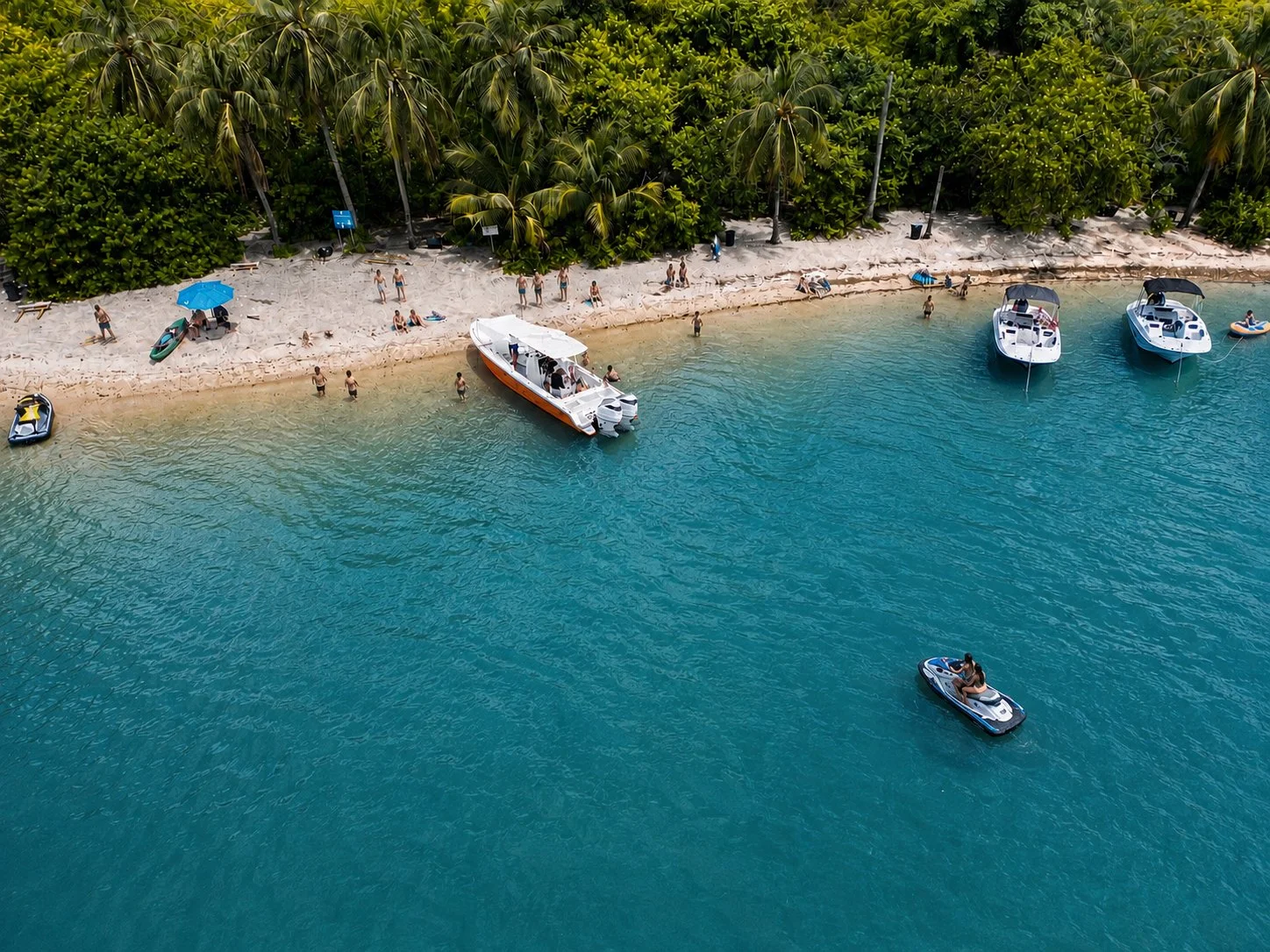 Aerial view of power boat beached at tropical island.