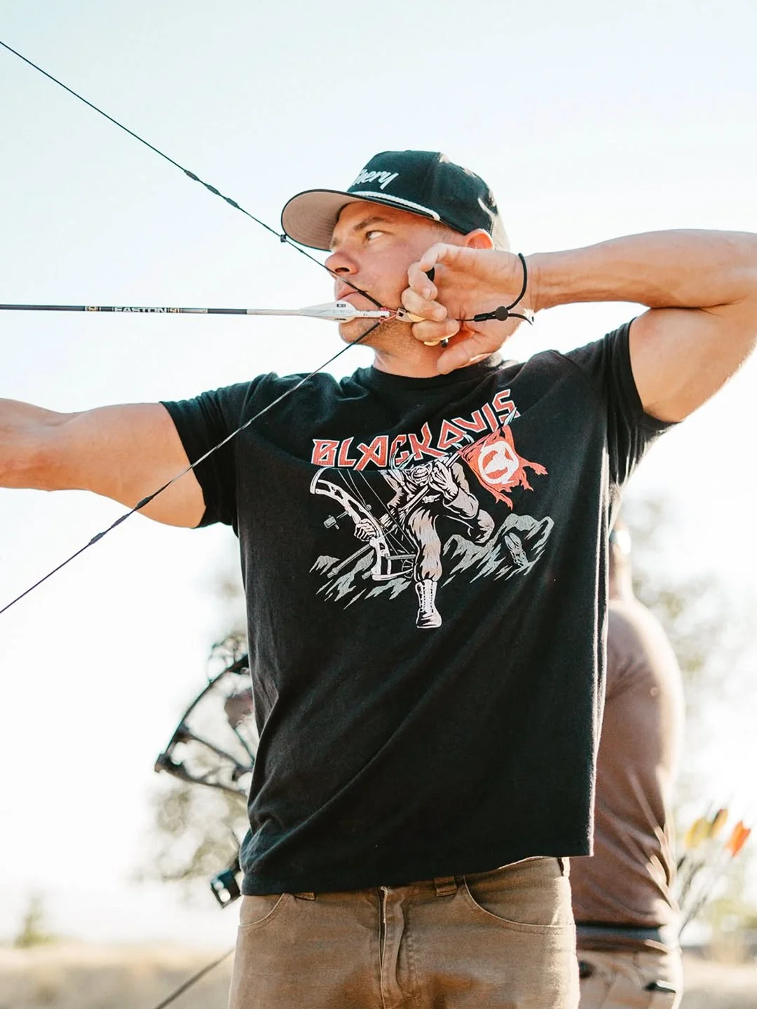 Archer wearing custom BlackOvis heavy metal inspired bowhunting t-shirt during archery practice.