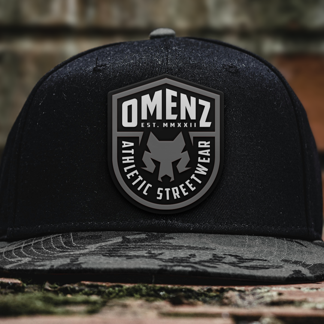 Black hat featuring the Omenz wolf icon badge logo designed for athletic streetwear branding.