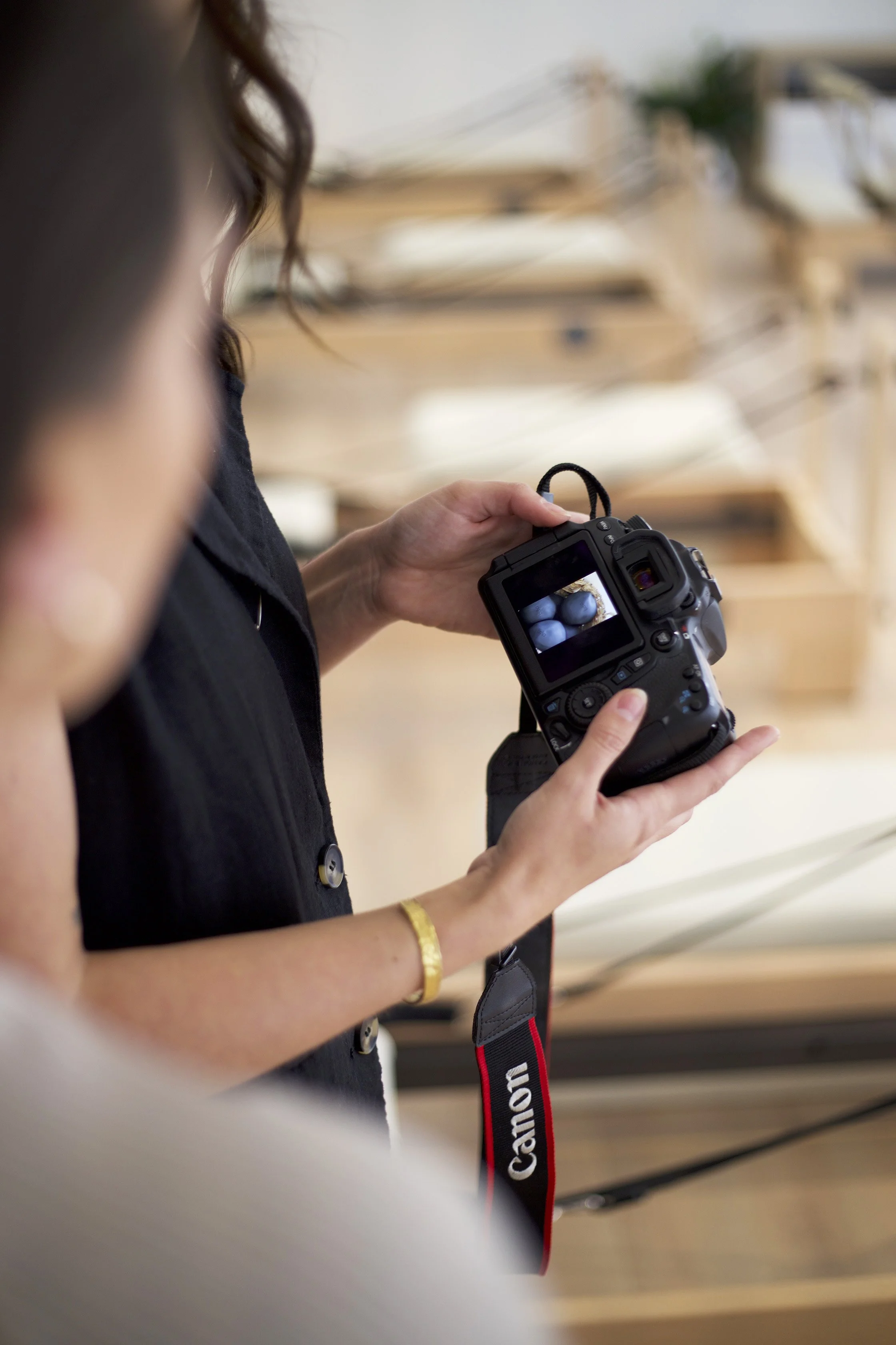 People looking at a camera's LCD screen showing a photo of blue stones.