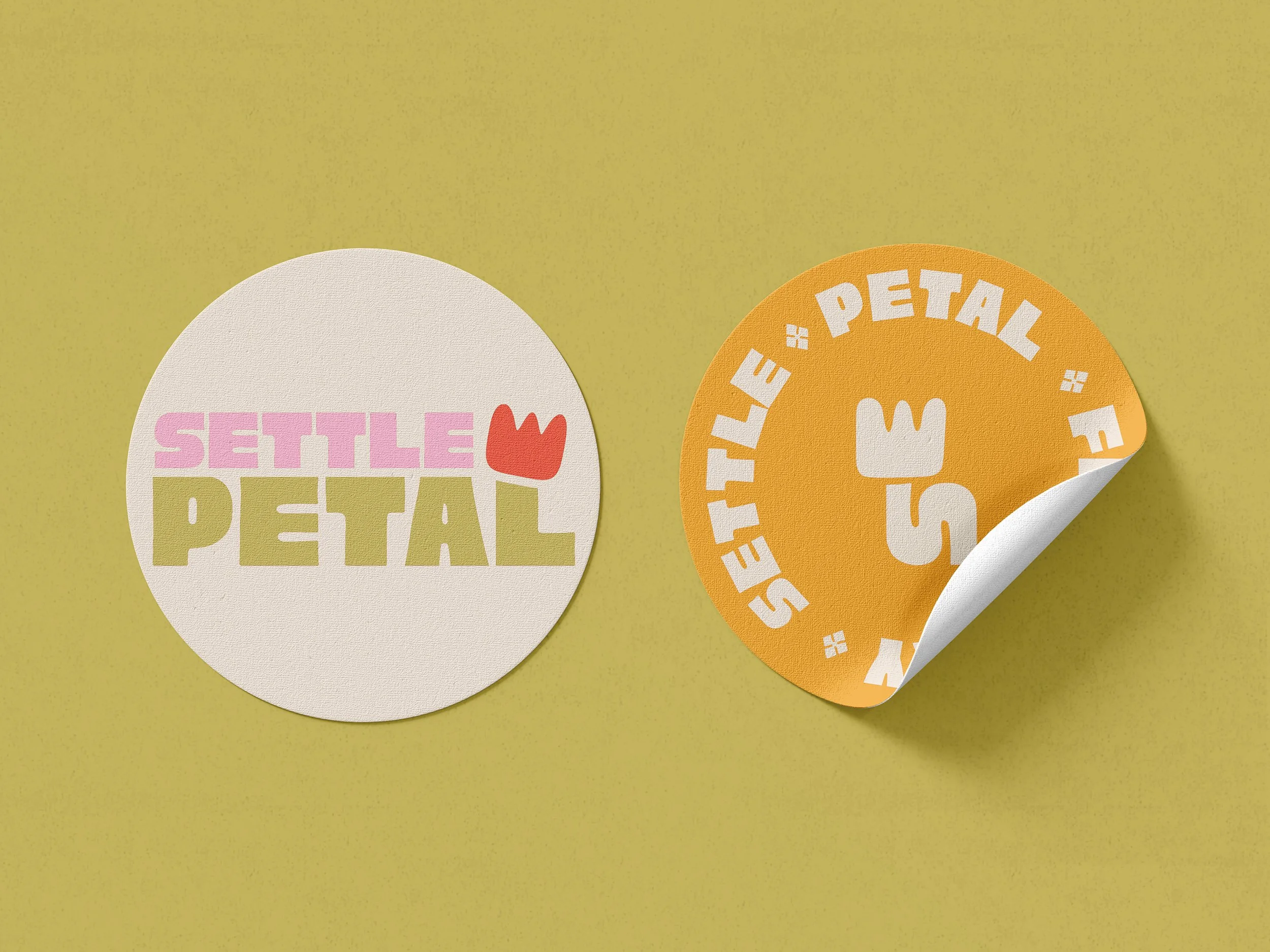 Two round stickers on a yellow background. The left sticker is white with pink, green, and red text saying "Settle Petal" with a small red flower above the text. The right sticker is orange with white text saying "Settle Petal" in a circular pattern around a white fork icon, with one corner curling up to reveal the white underside.