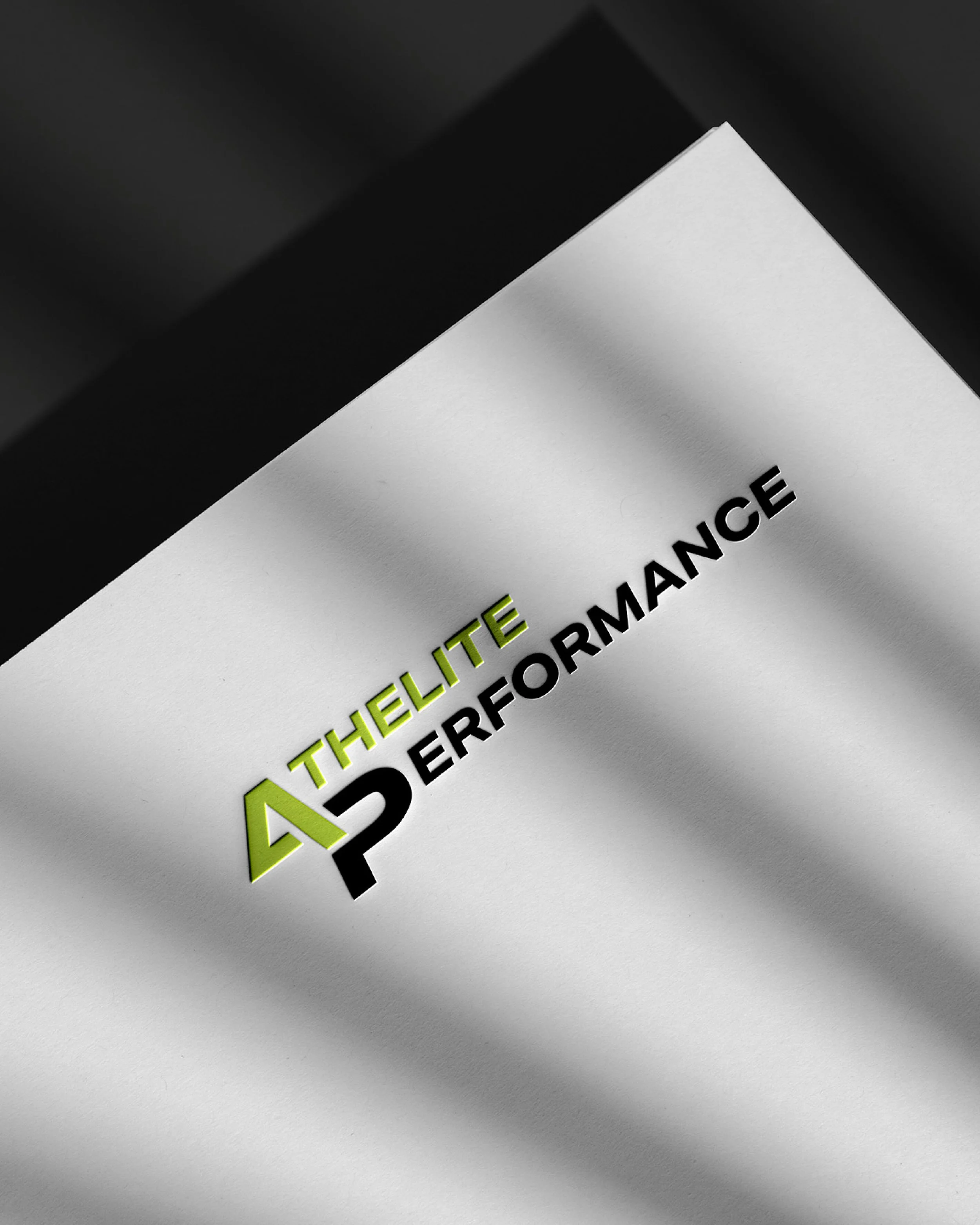 Close-up of a paper with the words 'The Elite Performance' printed, featuring a stylized logo with the letter 'A' in green and 'P' in black.