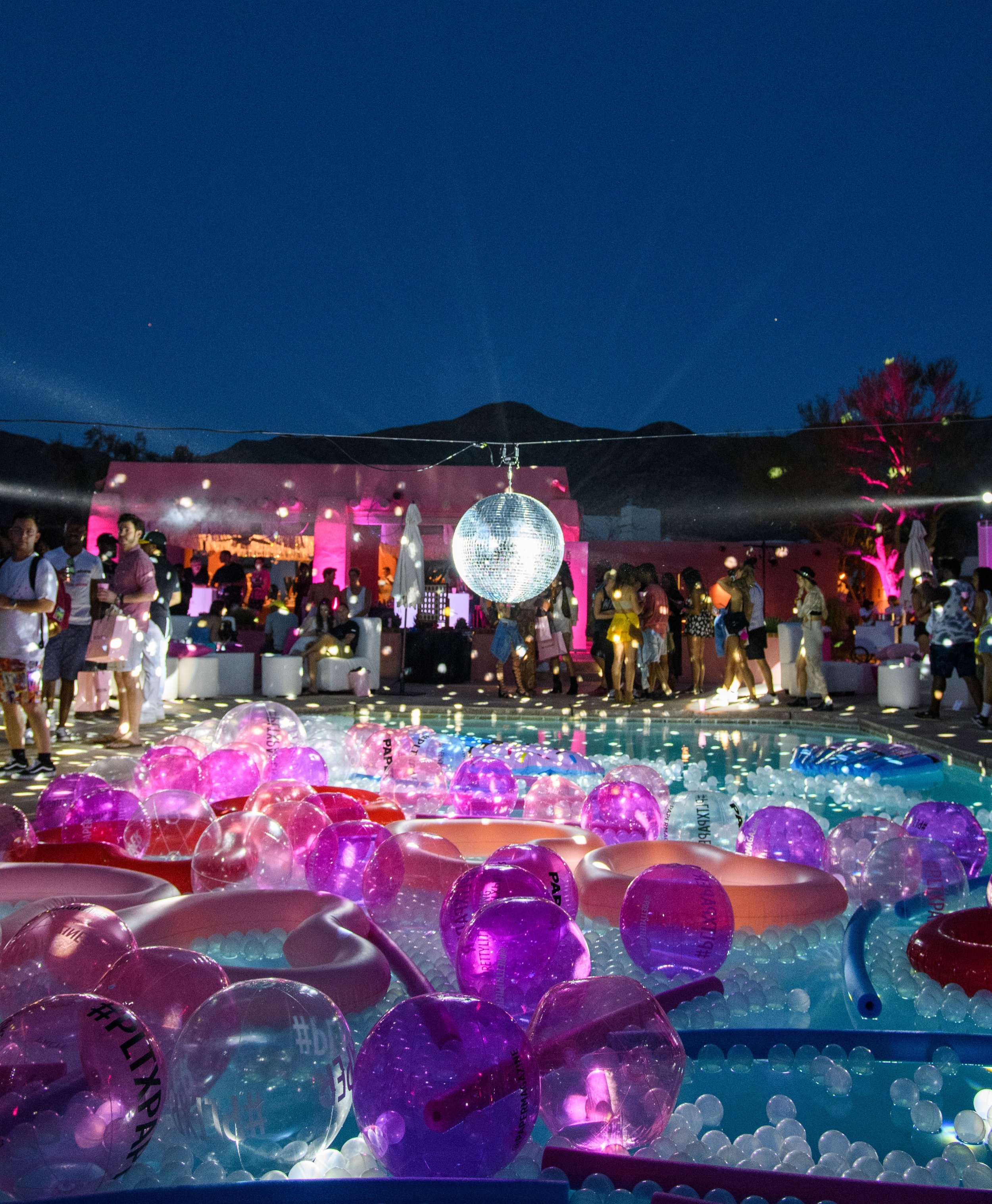 Ultimate Hollywood Coachella Poolside Party disco ball spins above the pool rays shine behind.jpg