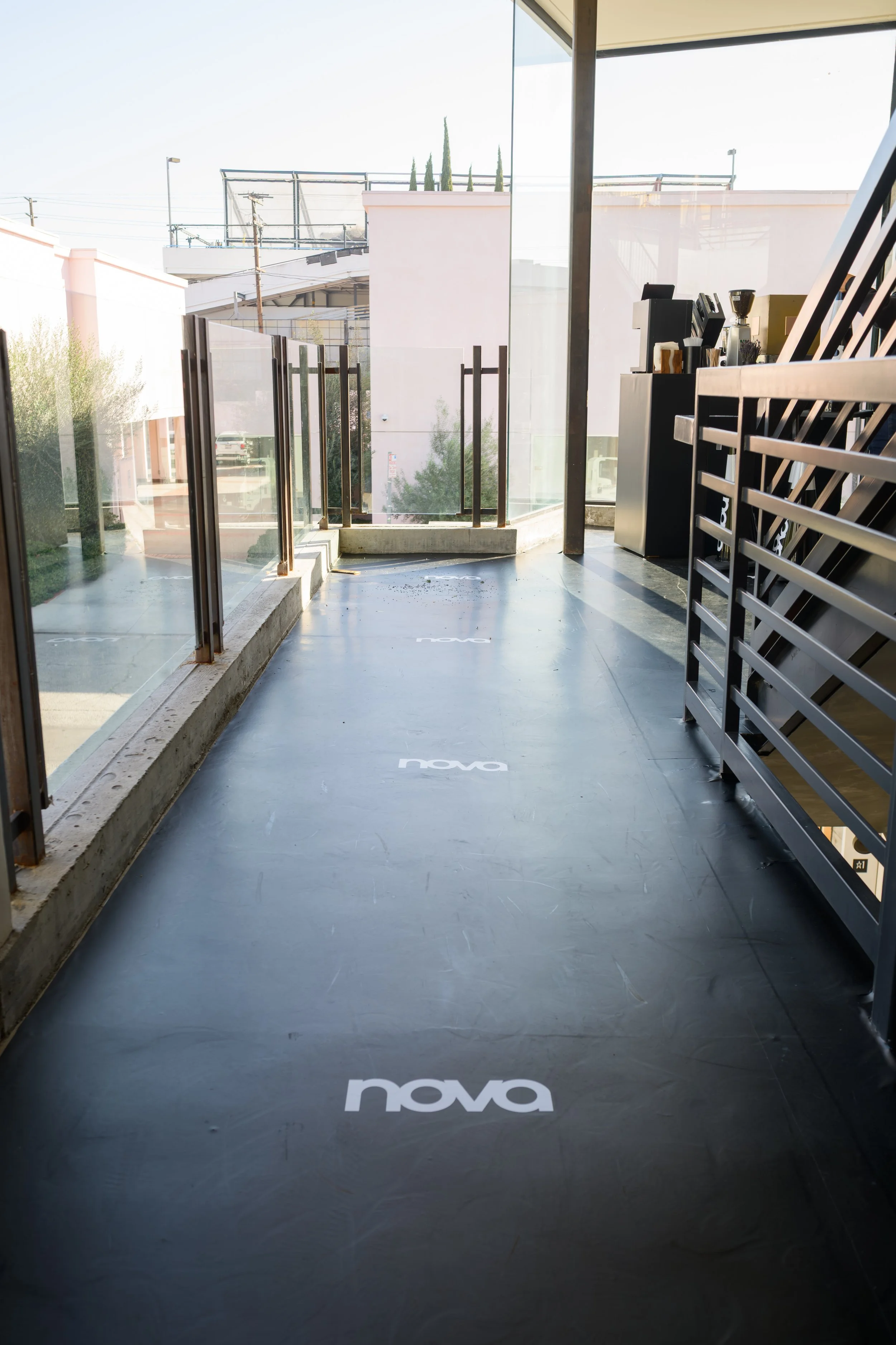 Fashion Nova logo custom walkway installation leading into Nova Fitness studio experience designed and produced by Wife of the Party