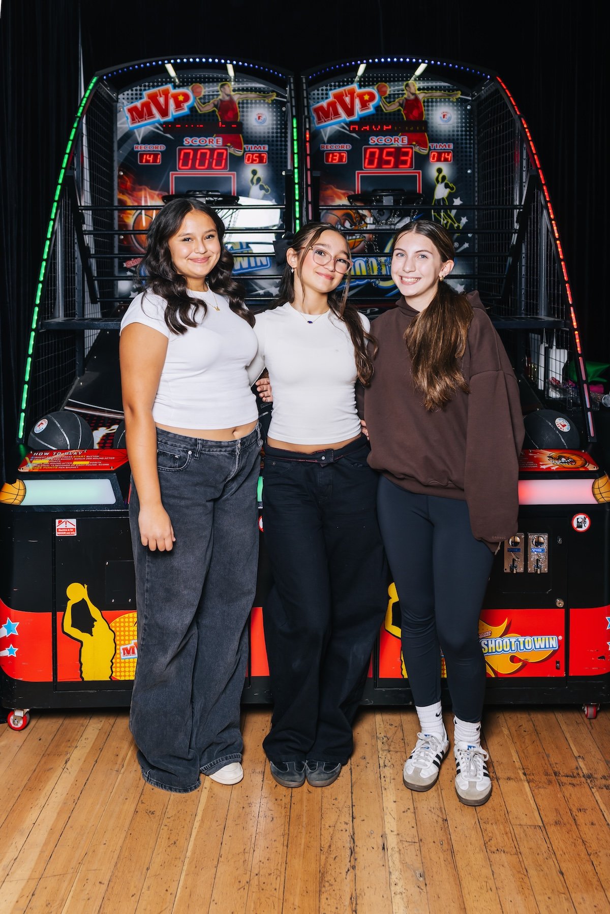Wife of the Party and Guests posing at interactive arcade themed birthday celebration