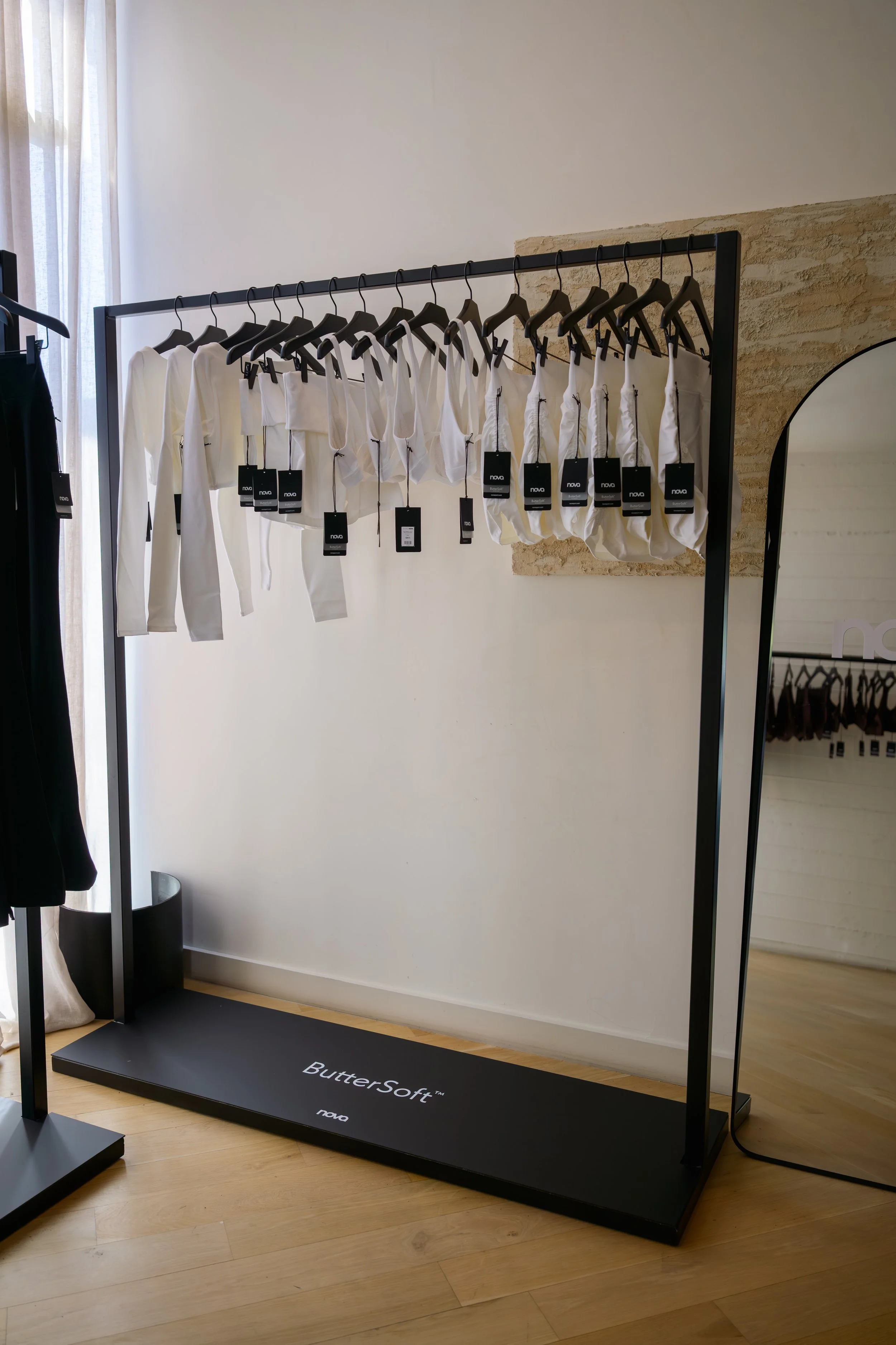 Nova Fitness apparel displayed in boutique fitness studio with Nova branded mirror and modern activewear racks at Fashion Nova launch produced by Wife of the Party
