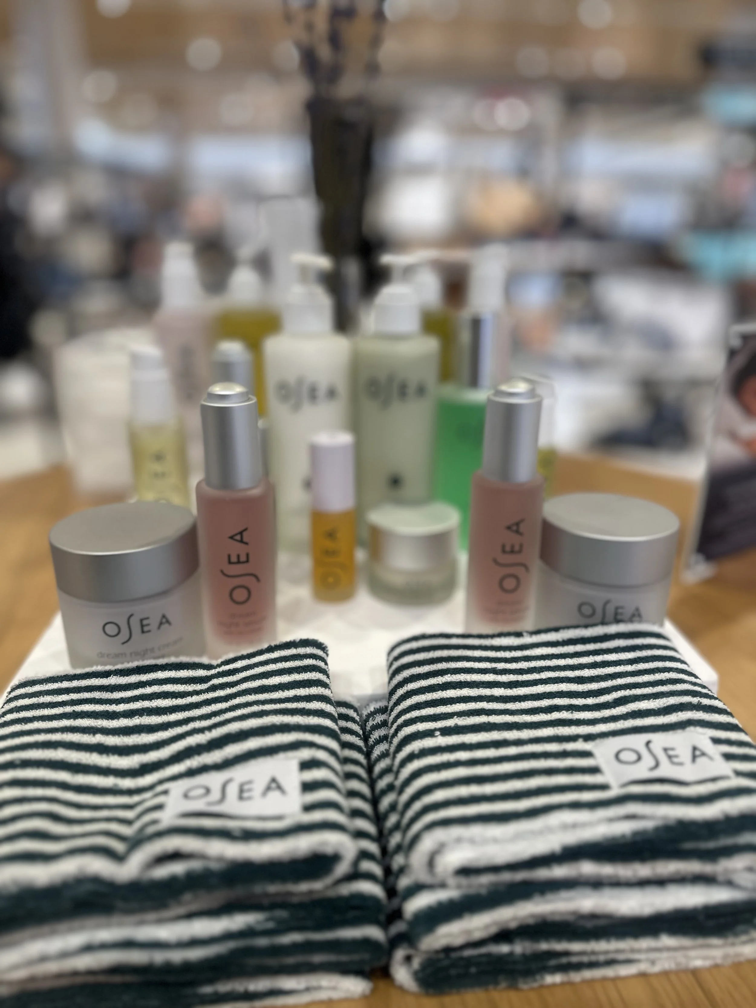 OSEA skincare products and branded towels displayed during a wellness-inspired Nordstrom pop-up produced by Loriann Serna of The Wife of the Party.