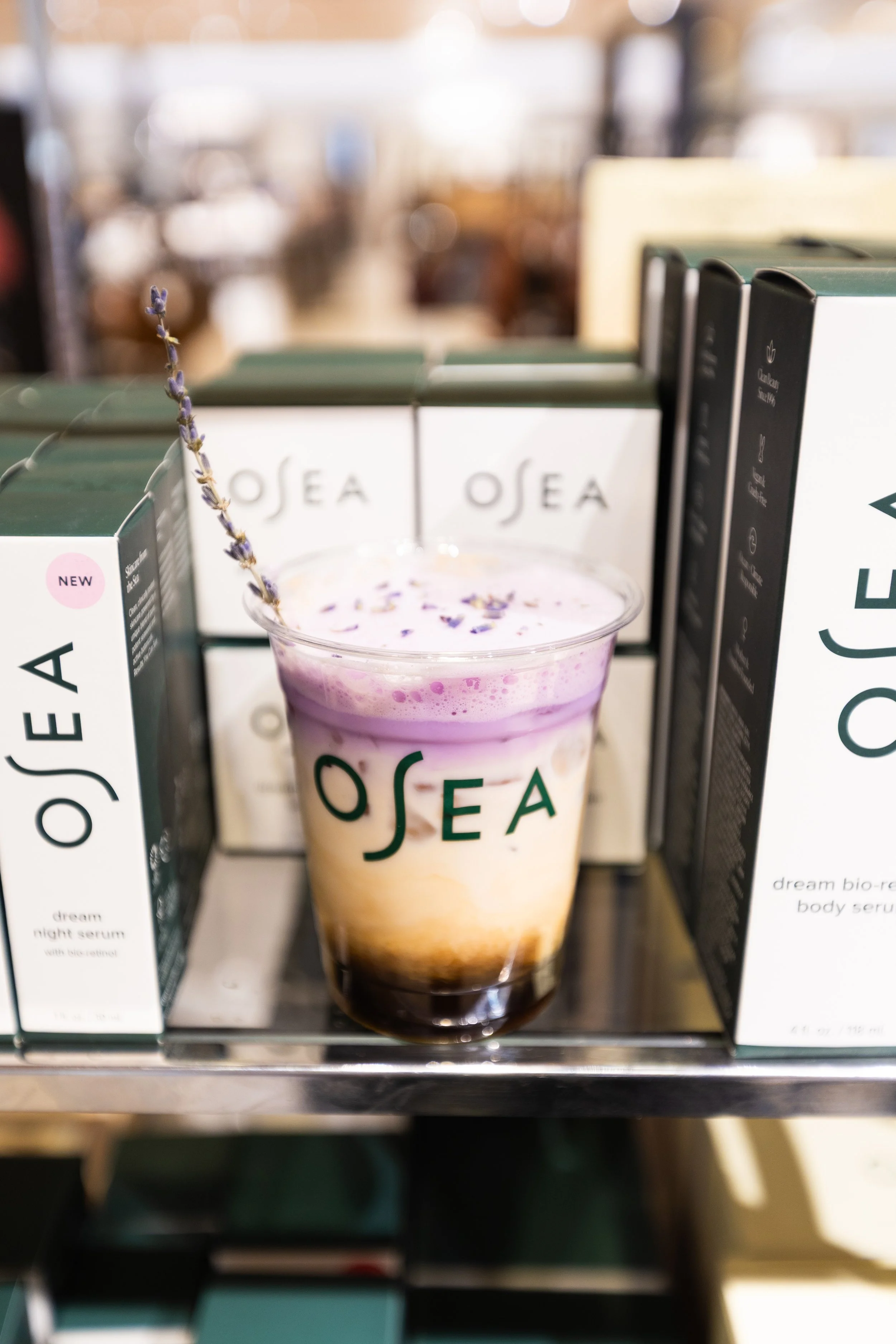 Lavender coffee beverage displayed alongside OSEA skincare products during a branded experiential pop-up by Loriann Serna of The Wife of the Party.