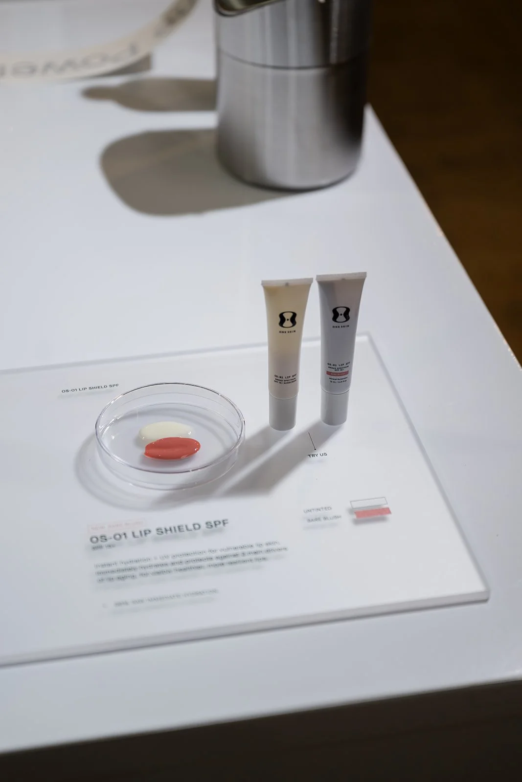 OneSkin OS-01 Lip Shield SPF product sampling display at influencer event activation
