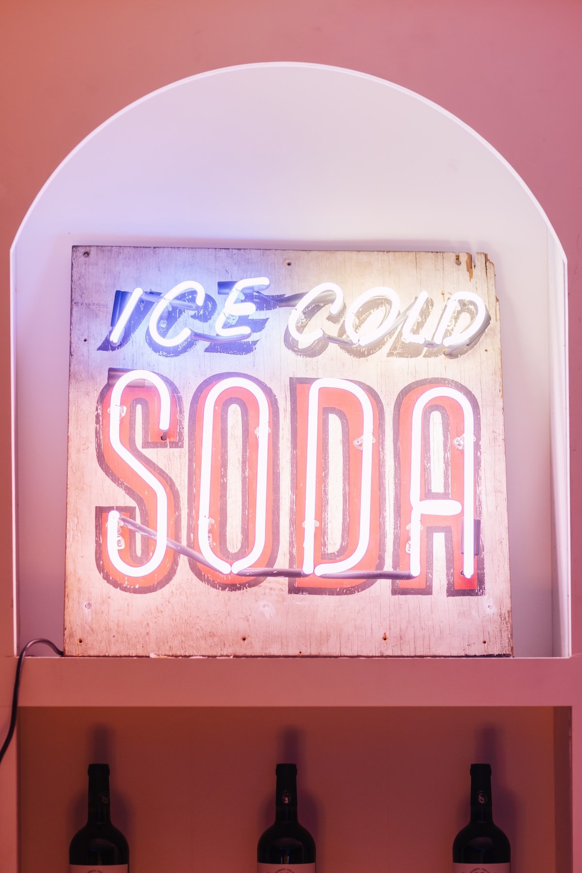 Signature cocktails including prickly pear margarita and paloma displayed at neon arcade themed birthday party bar by Wife of the Party