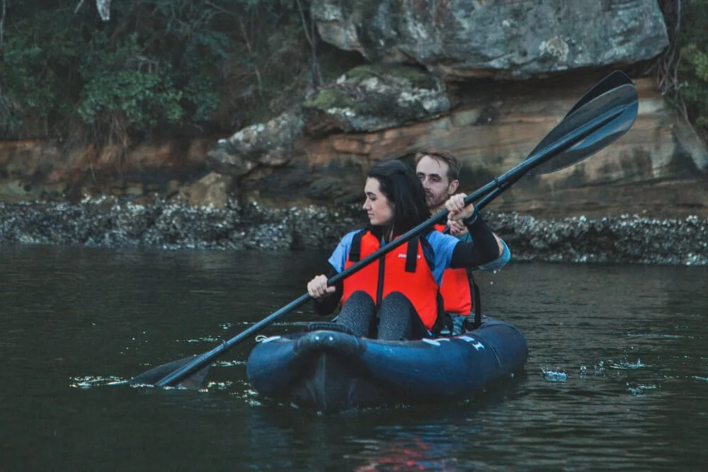 Front angle of a man and a woman out on a lake in the R2 Ultra wearing red life jackets