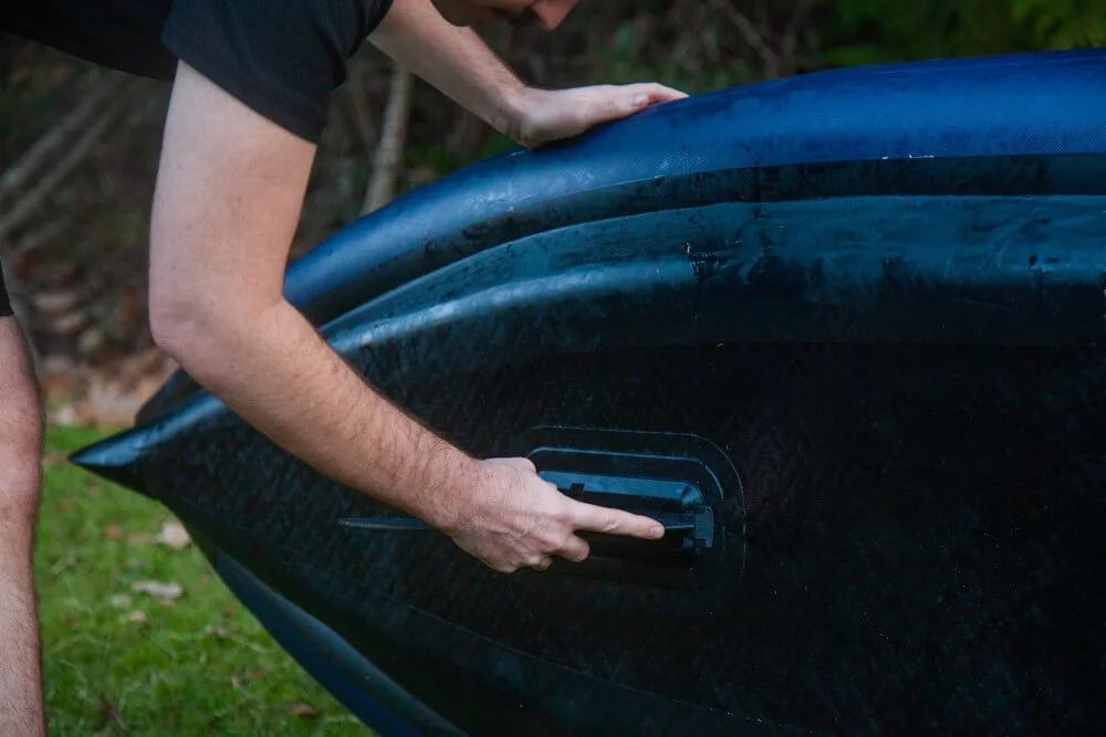 A close up of a man attaching the removable fin to the underside of the R1 Ultra