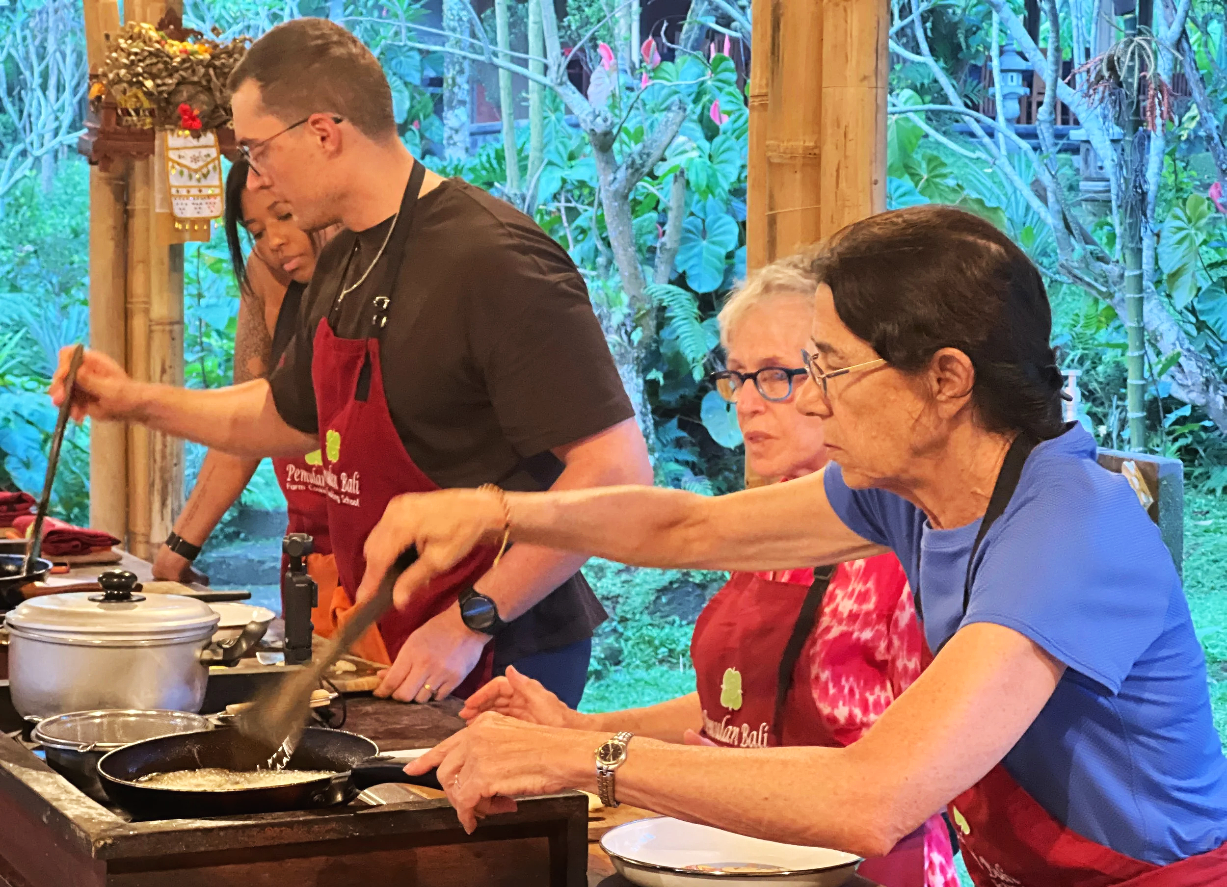Guests preparing traditional Balinese dishes during cooking class in Bali