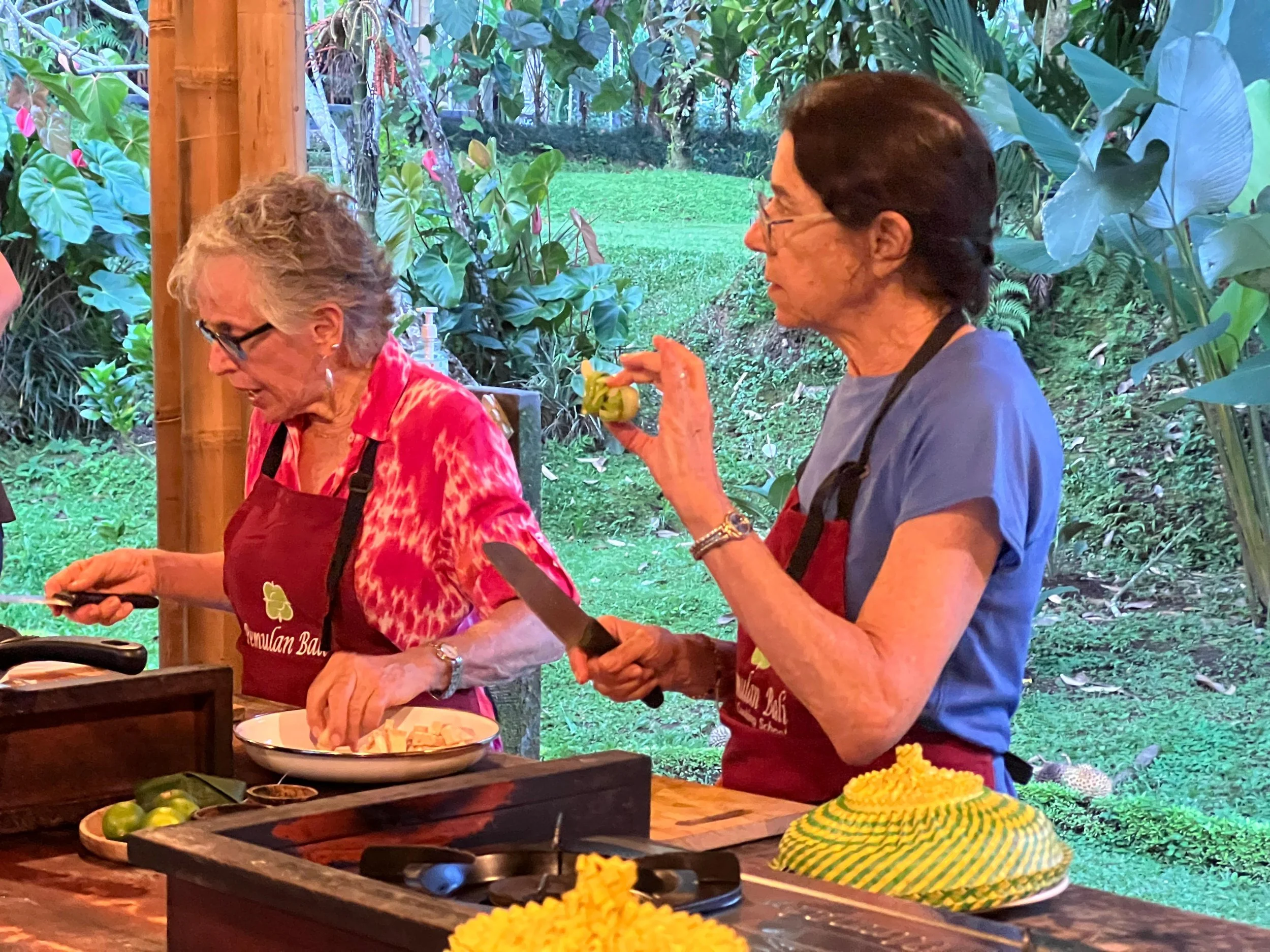 Guests preparing traditional Balinese dishes during cooking class in Bali