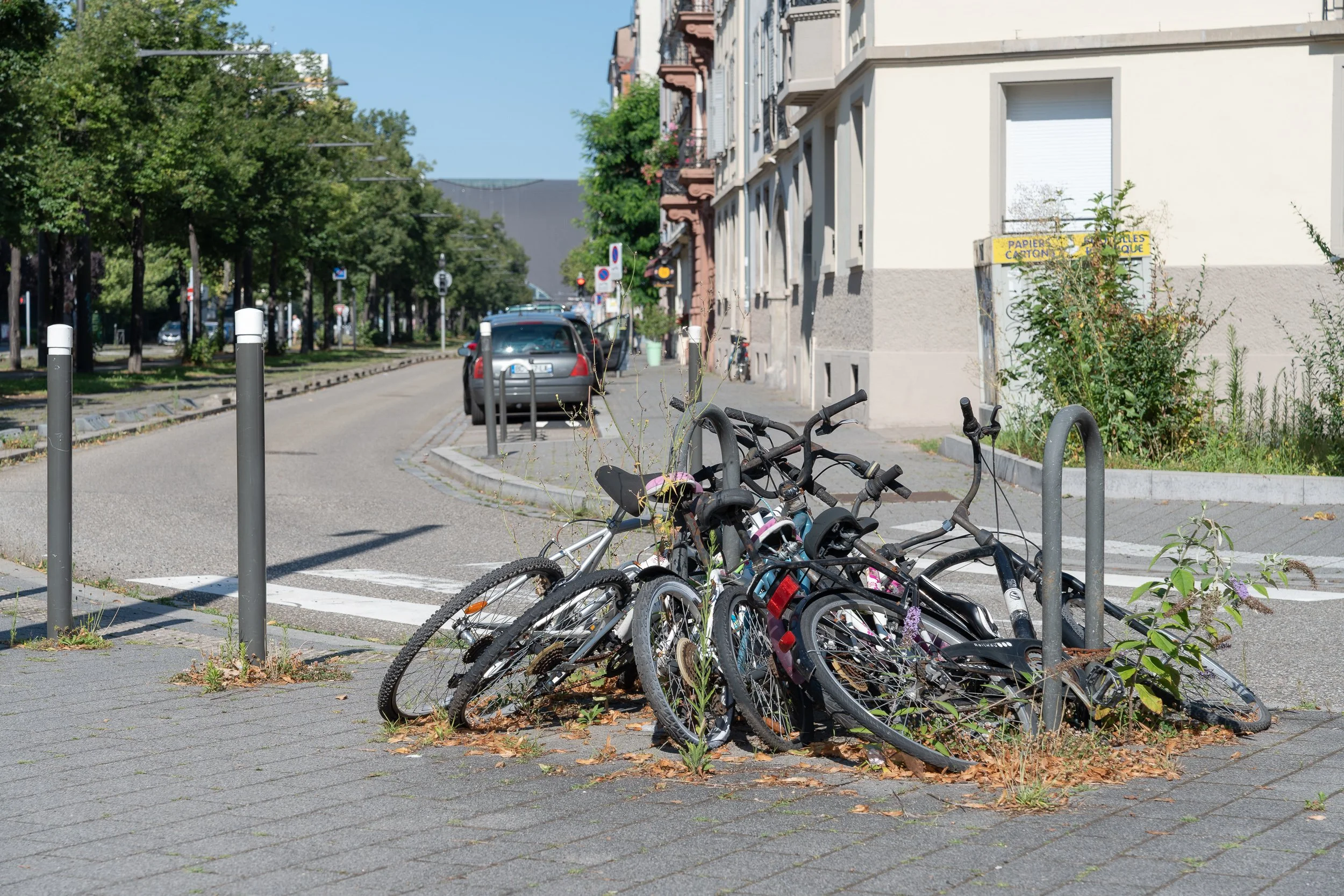 Pile of abandoned bicycles lying around a street bike rack in Strasbourg.