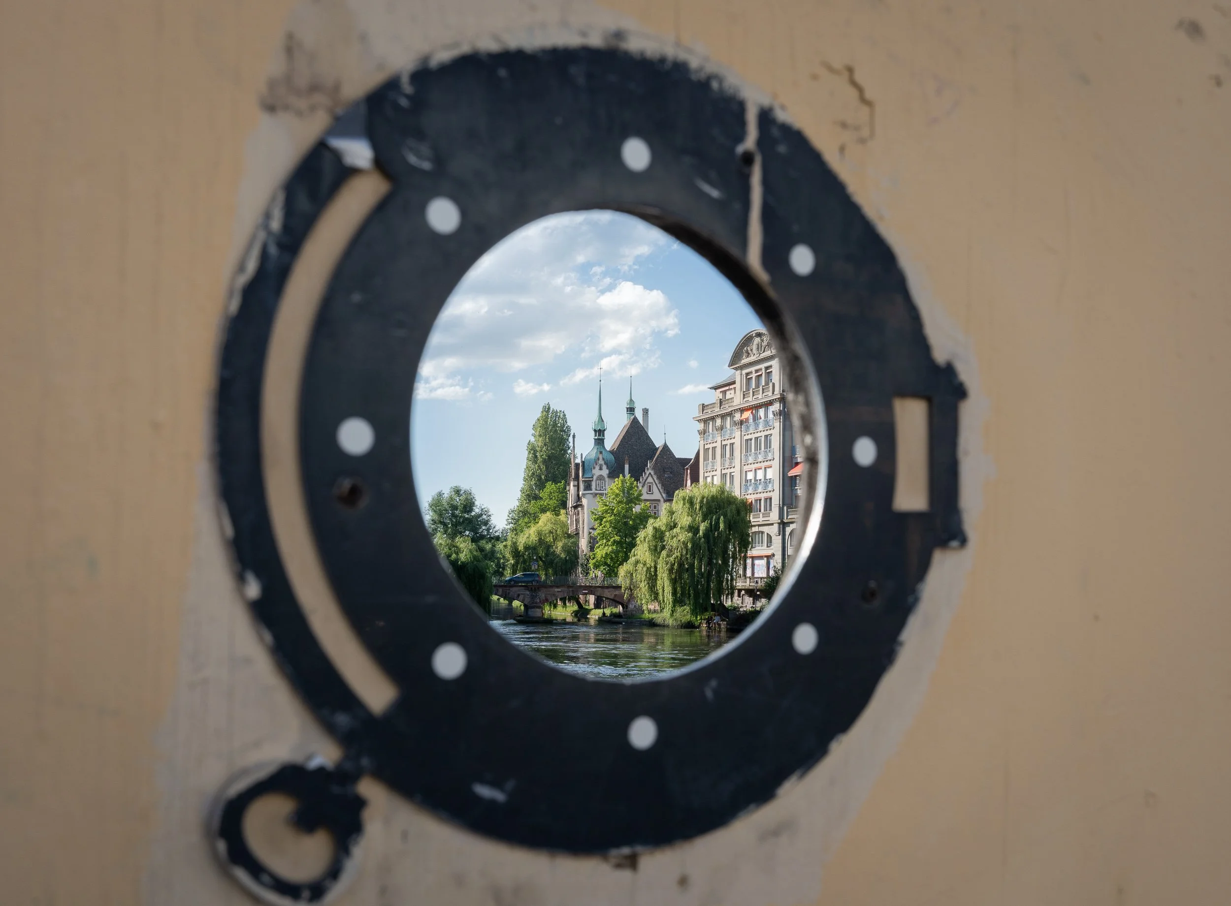View of Strasbourg through a circular opening overlooking the river.