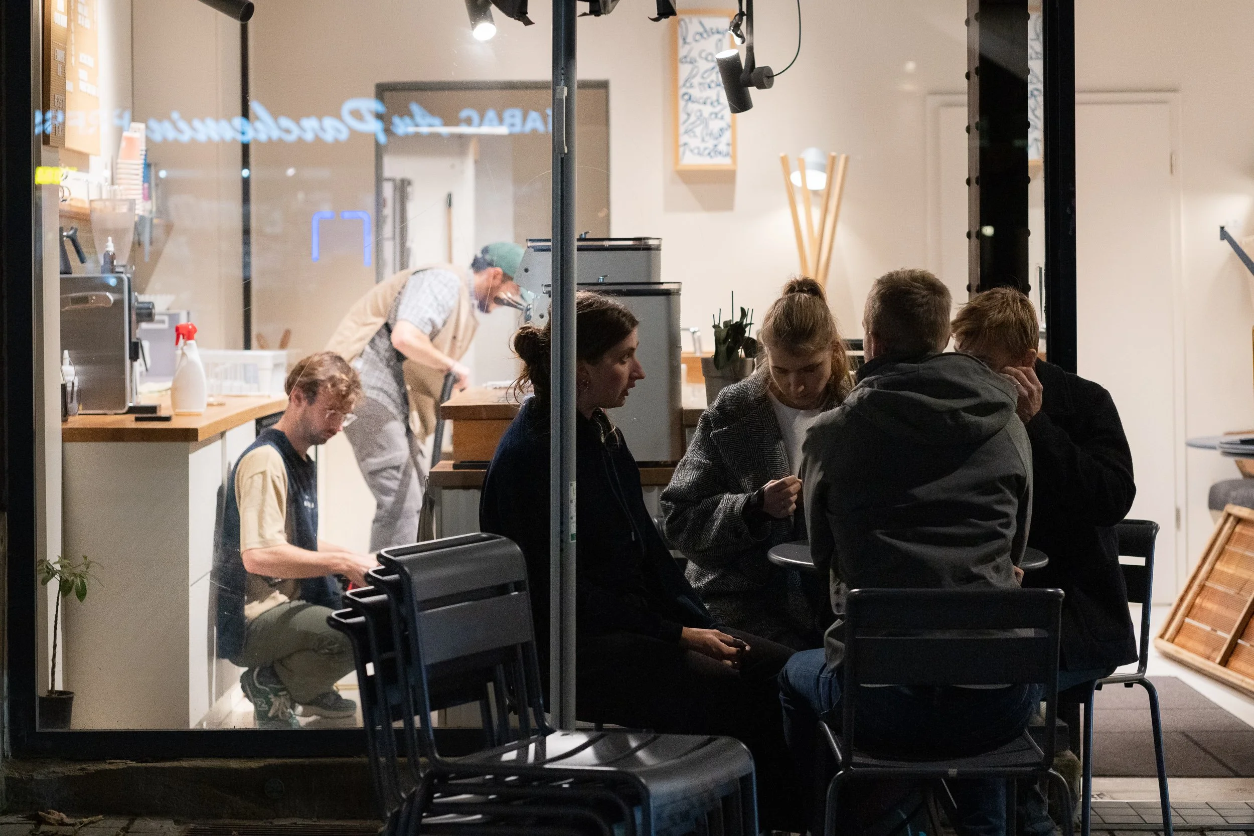 People gathered around a table inside a Strasbourg café at night.