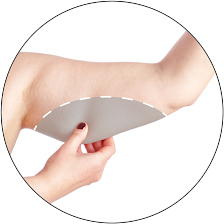A person holding a mirror against their inner upper arm to check the area.