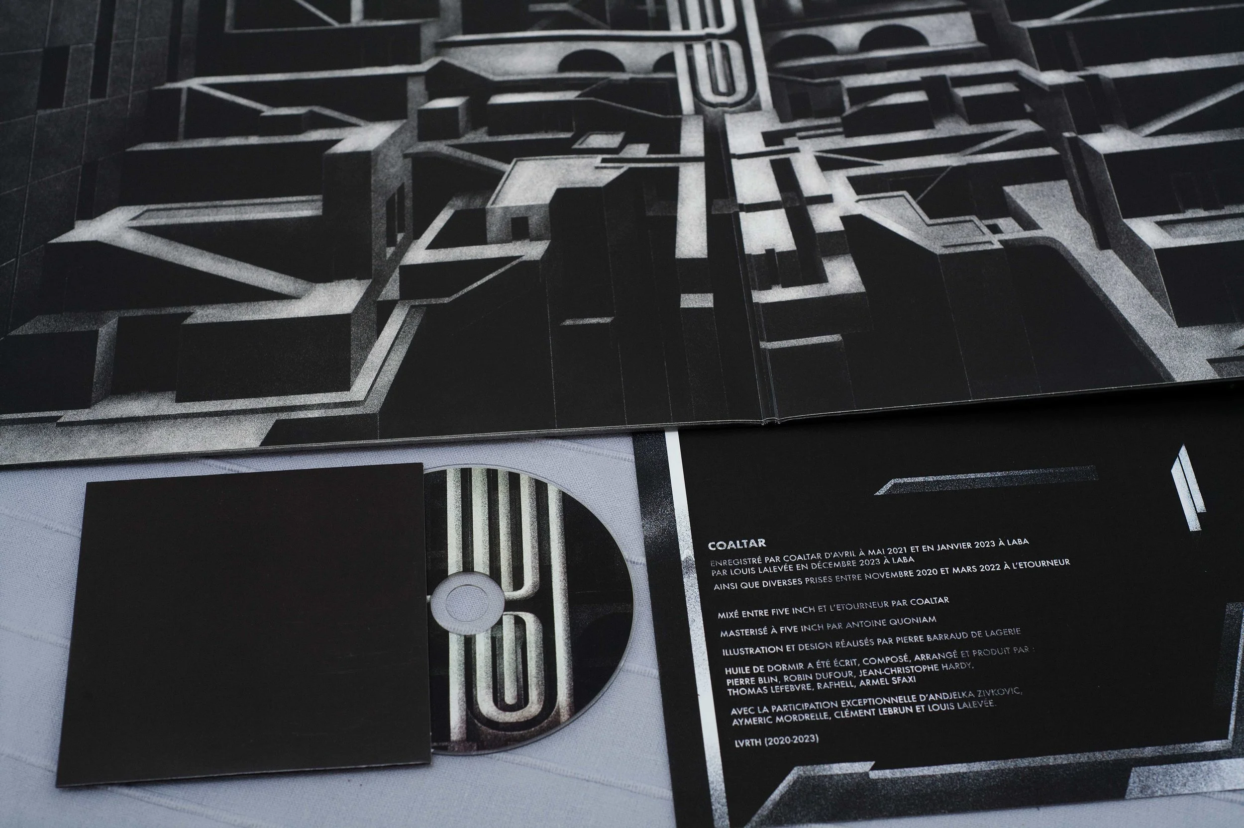 Un CD, une pochette vinyle du groupe Coaltar, album Huile de dormir