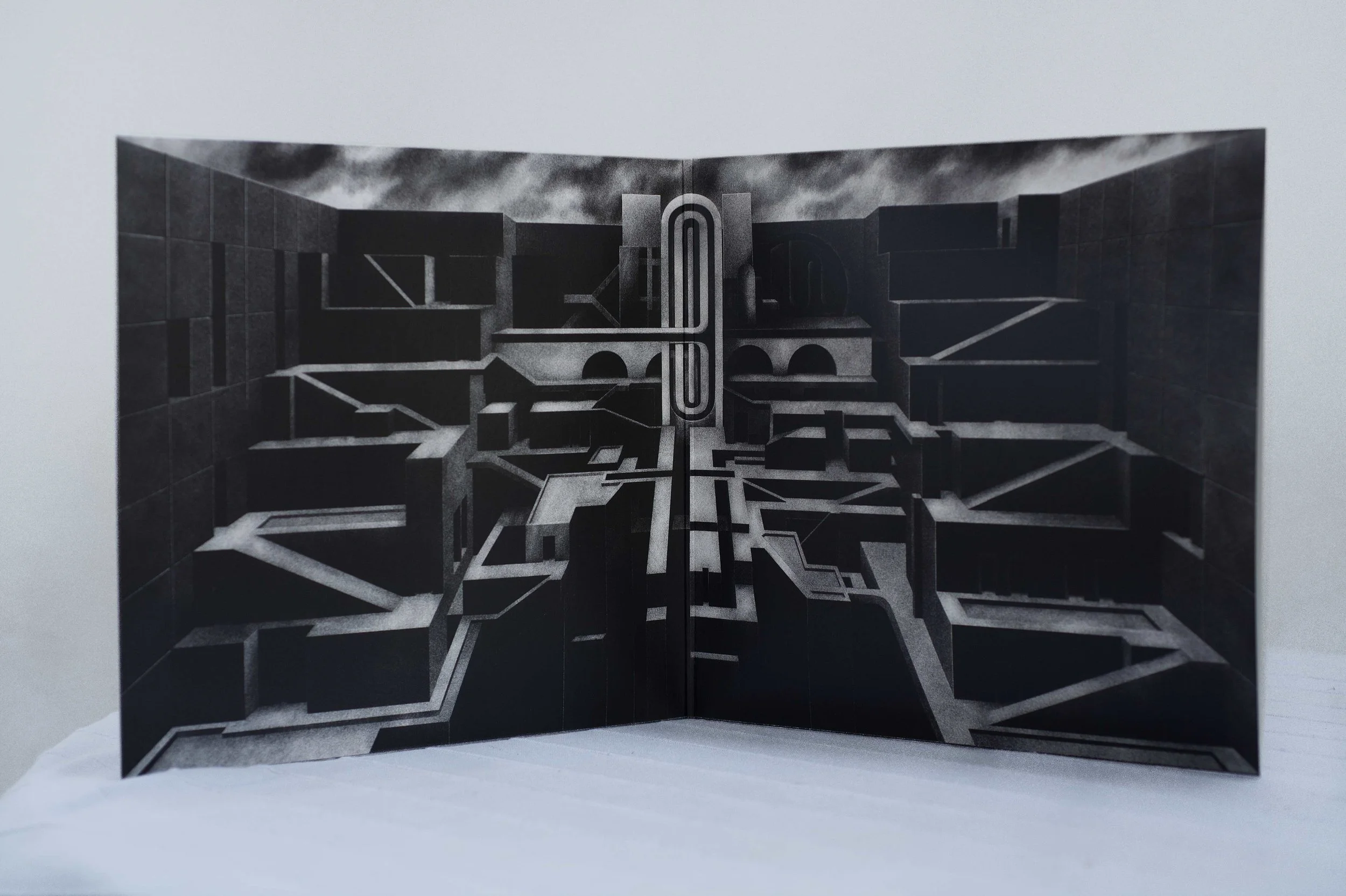 Une pochette vinyle ouverte, posée sur la tranche montrant le dessin intérieur en noir et blanc en format paysage présentant un paysage architectural abstrait avec des escaliers et passages dans un style brutaliste.  