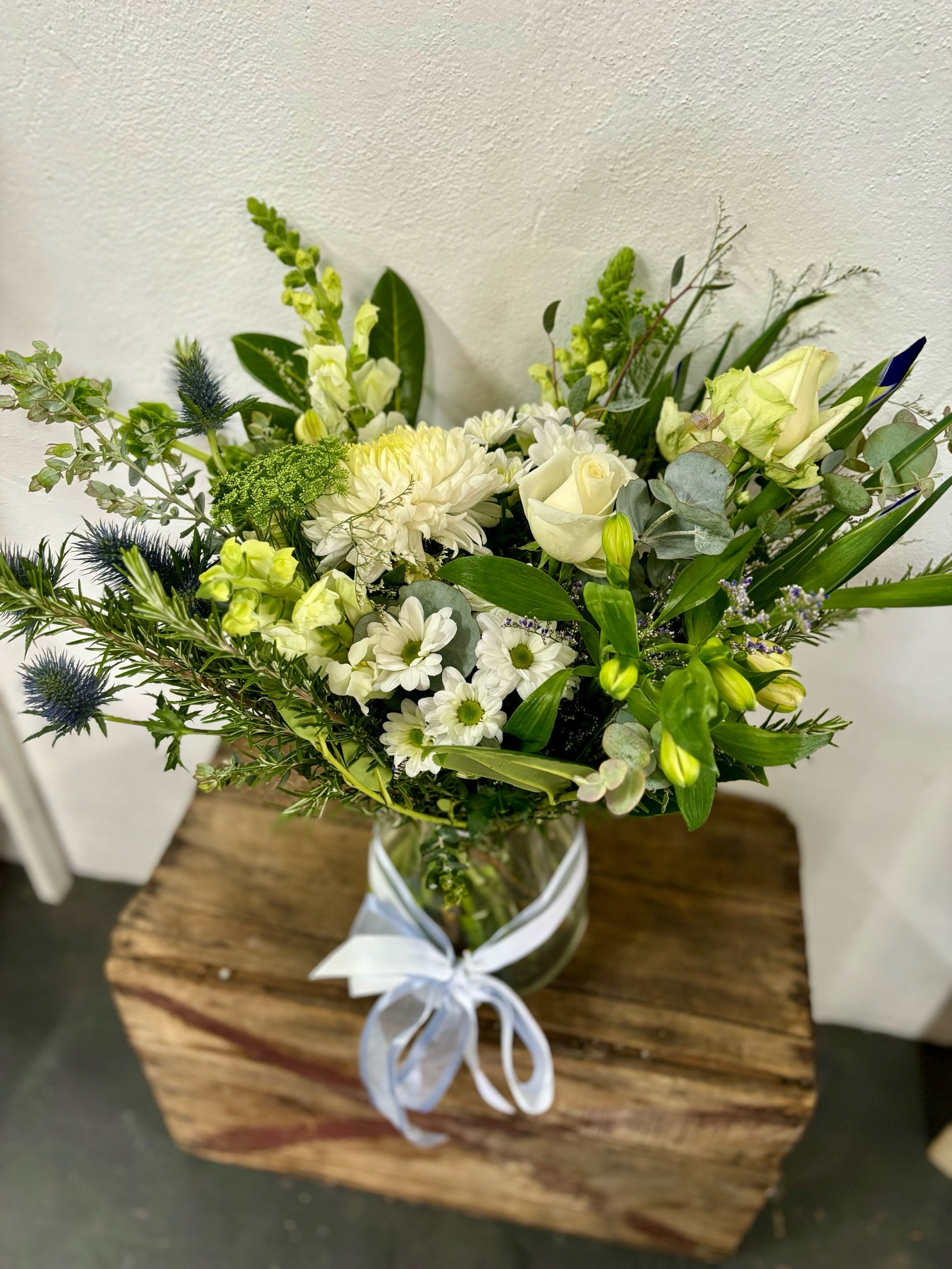 Vase of white and green seasonal flowers