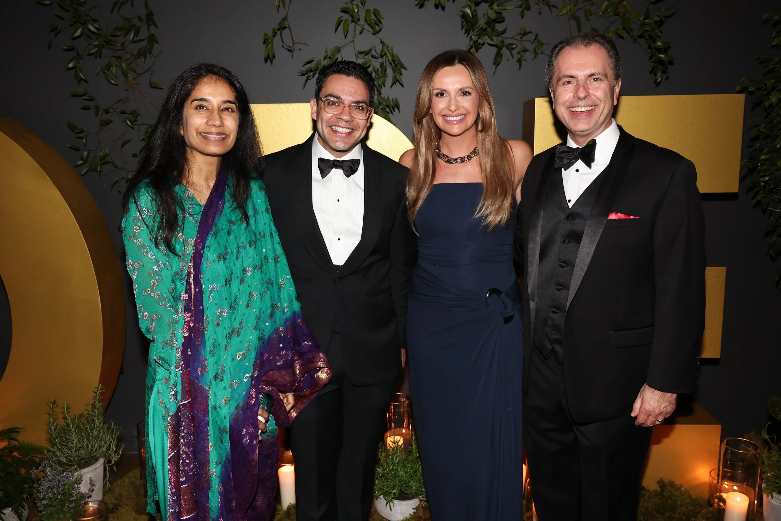 Ascension charity gala designed by Charlie Grey Events, including country music artist Carly Pearce and Ascension Saint Thomas CEO Fahad Tahir, posing in front of gold event décor and candlelit greenery.