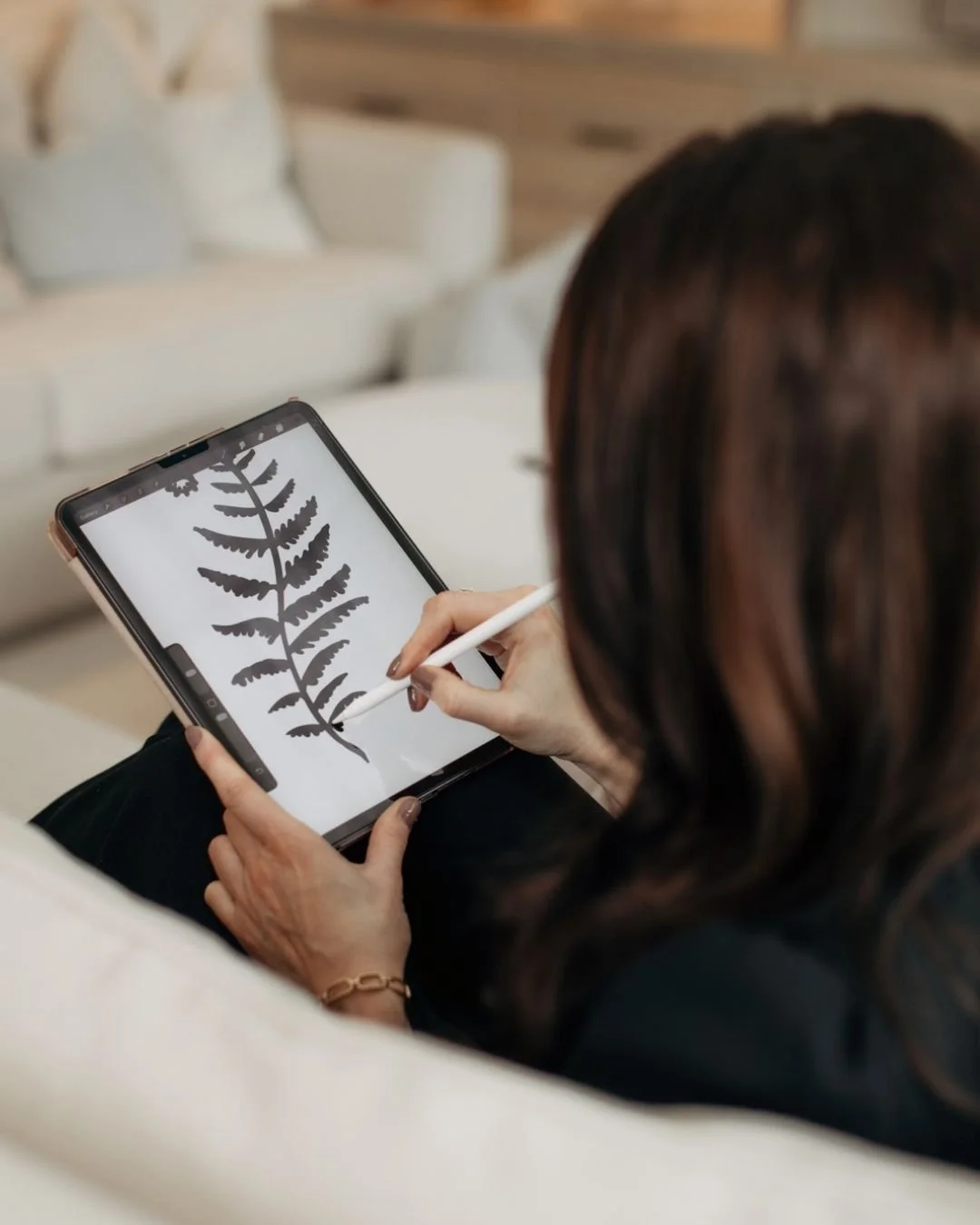 Designer sketching the Fern Anderson Interiors fern leaf brand mark on iPad, part of the visual identity development for the founder-led interior design studio.