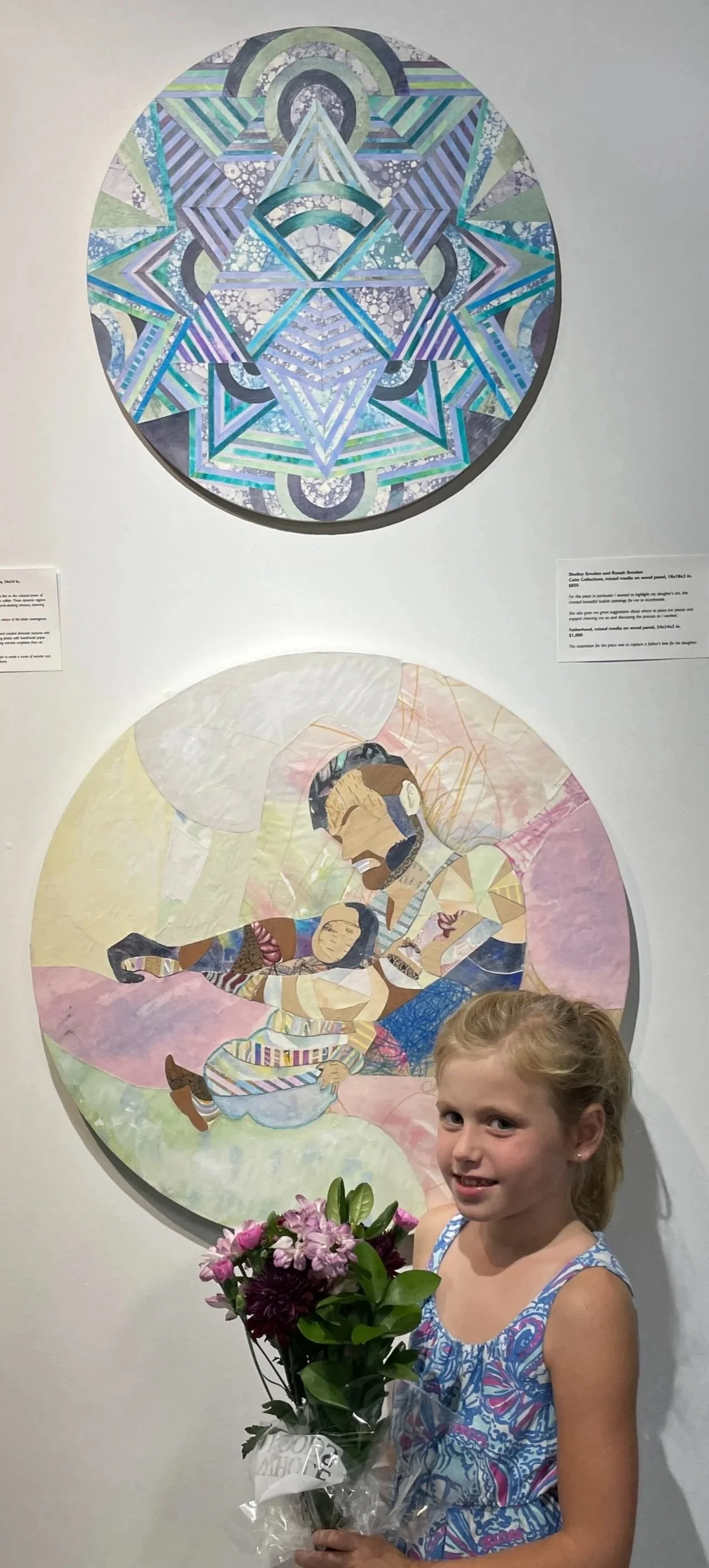 A young girl with blonde hair holding a bouquet of flowers standing in front of colorful artwork in an art gallery.
