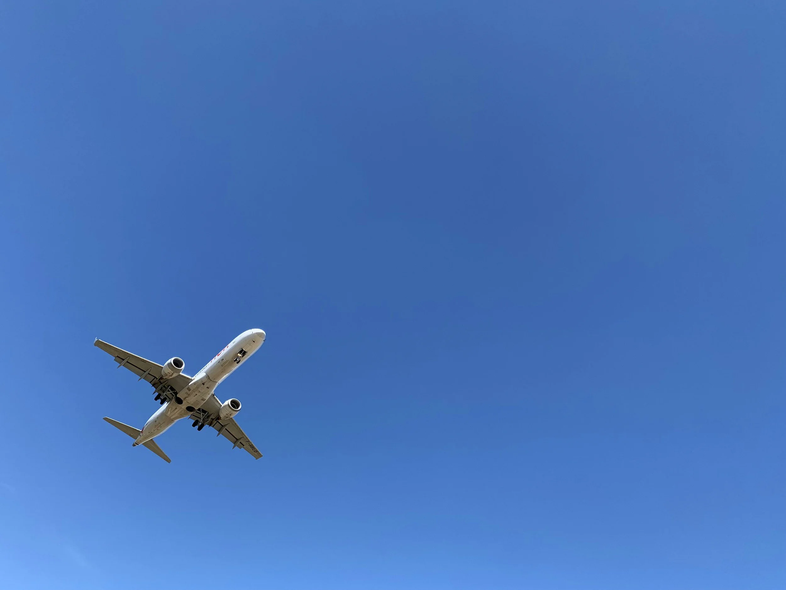 a flying airplane against a blue sky